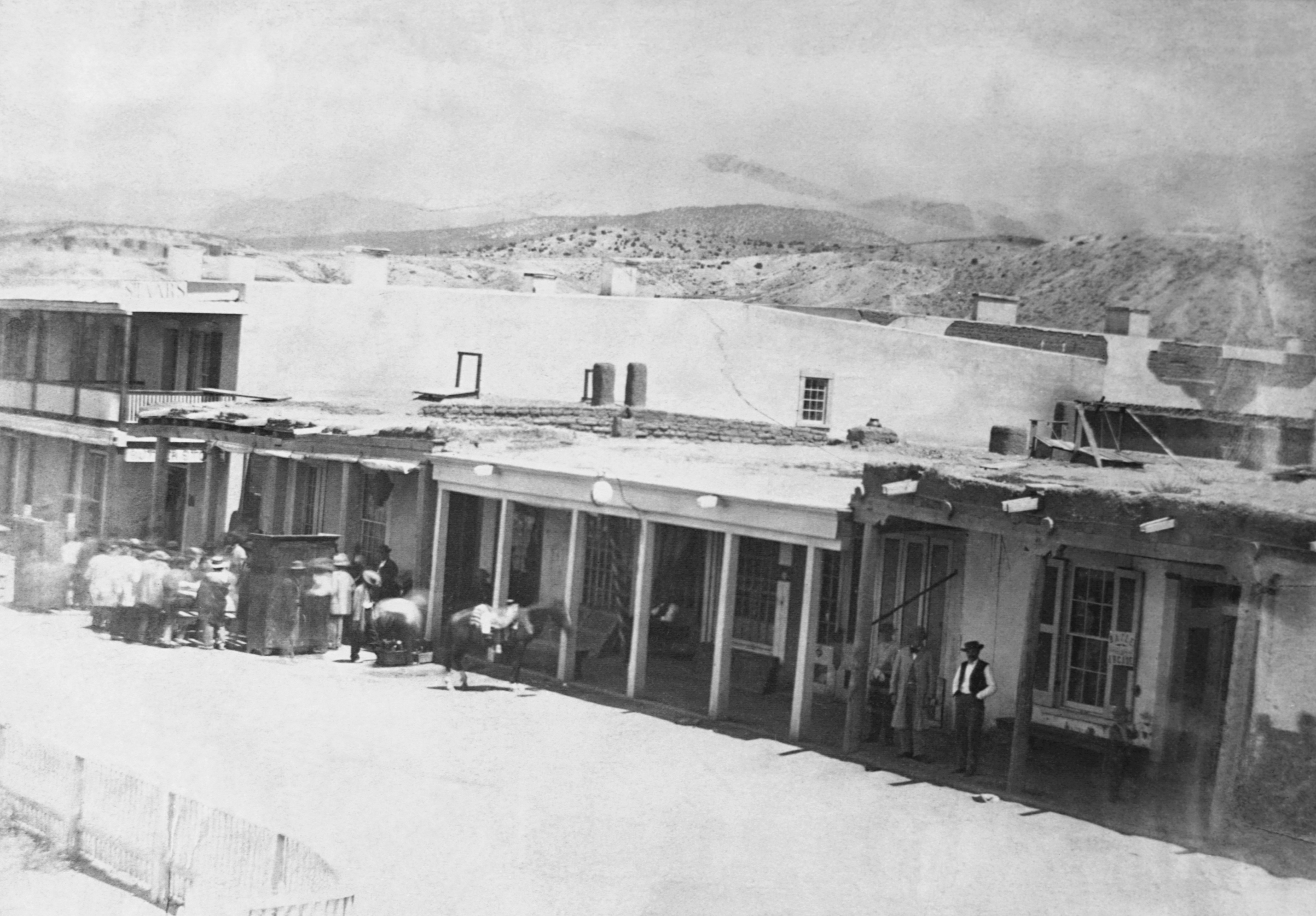 People stand on the sidewalk and in the street at the east side of Plaza in Santa Fe, N.M., 1866. (Corbis via Getty Images)
