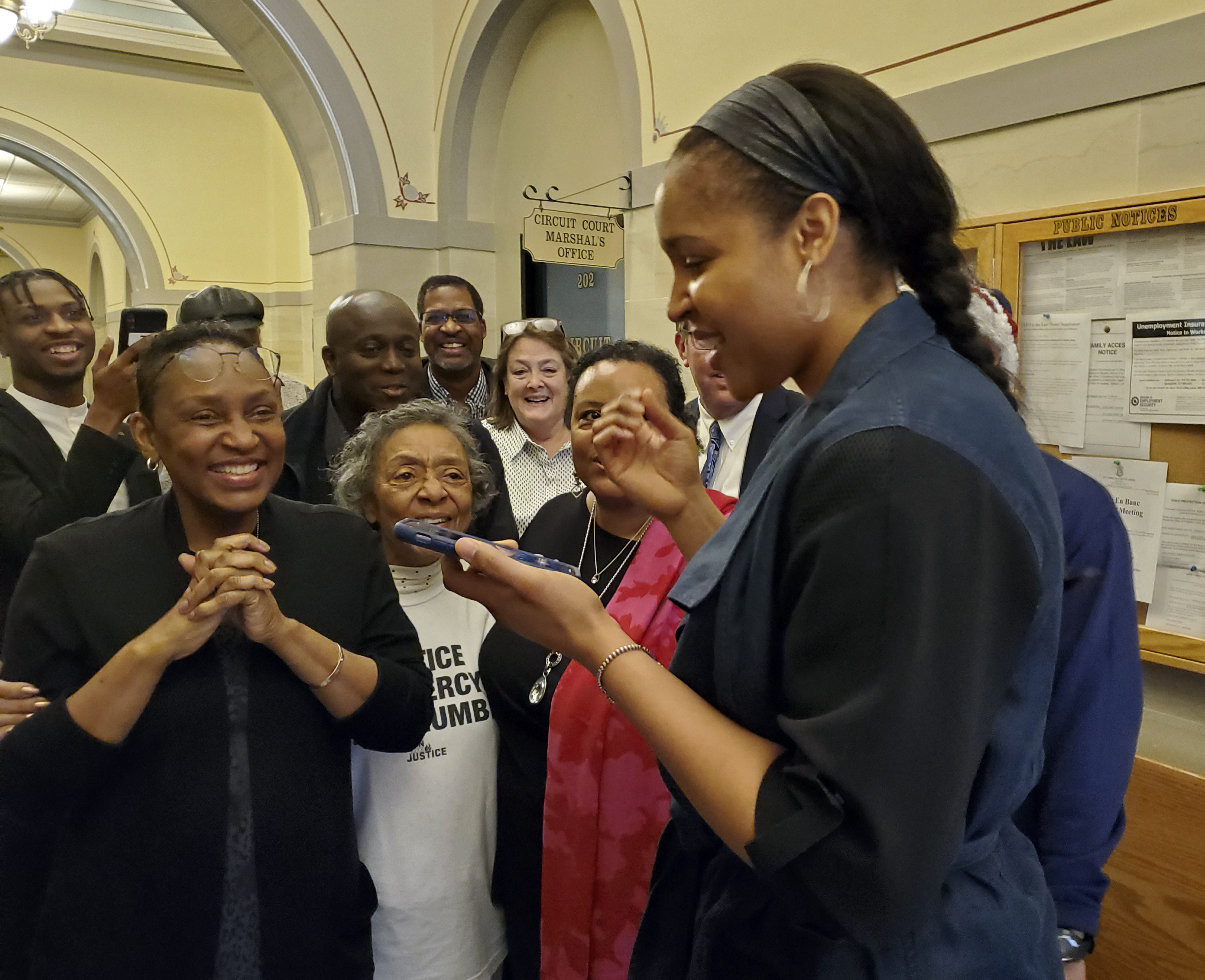 Jefferson City, Mo., native and WNBA star Maya Moore, right, calls Jonathan Irons as supporters react Monday, March 9, 2020, in Jefferson City after Cole County Judge Dan Green overturned Irons' convictions in a 1997 burglary and assault case. Moore, a family friend, had supported Irons, sharing his story on a national basis. (Jeff Haldiman/The Jefferson City News-Tribune via AP)