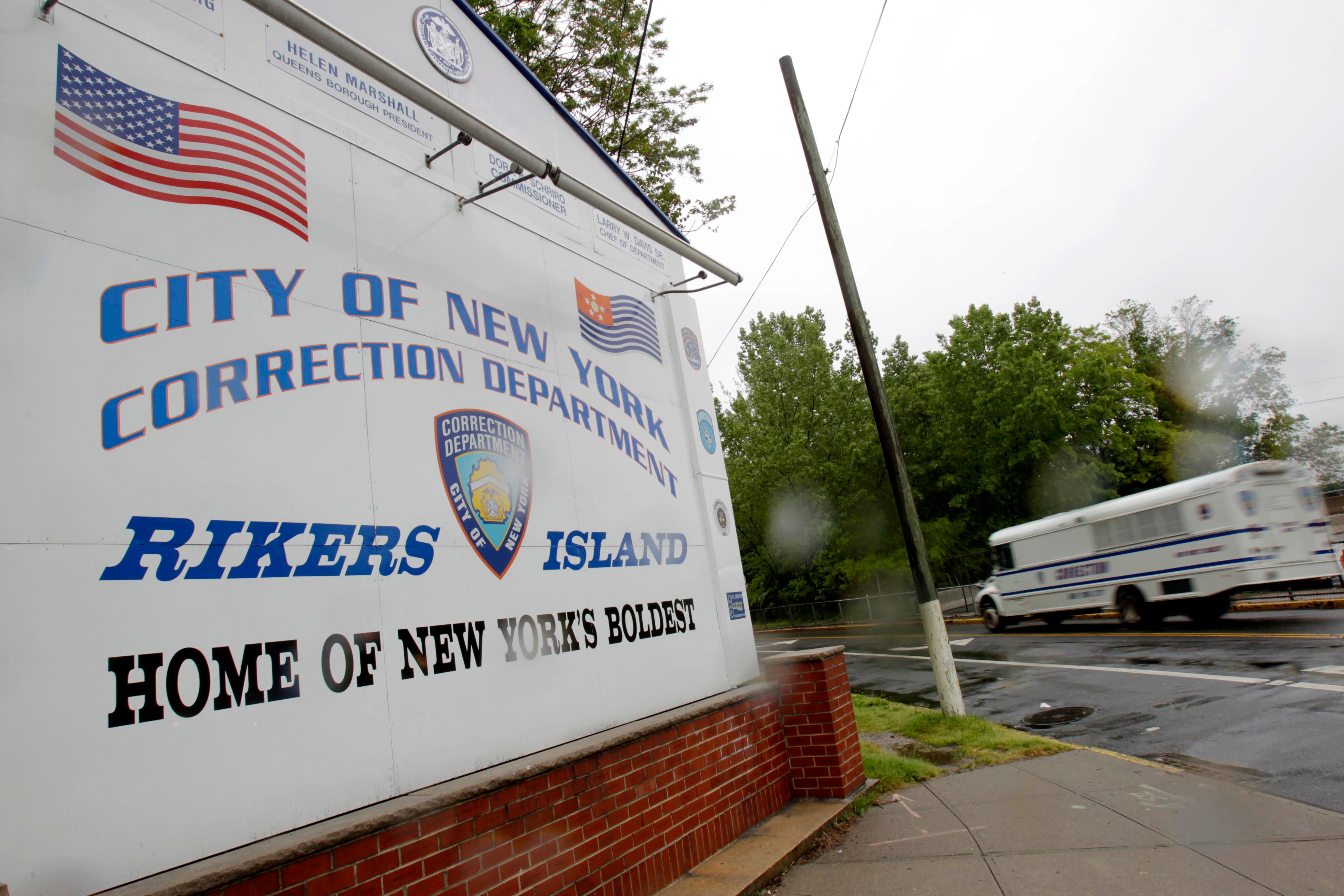 In this May 17, 2011  file photo, a New York City Department of Corrections bus passes the sign near the gate at the Rikers Island jail complex in New York. (Seth Wenig—AP)