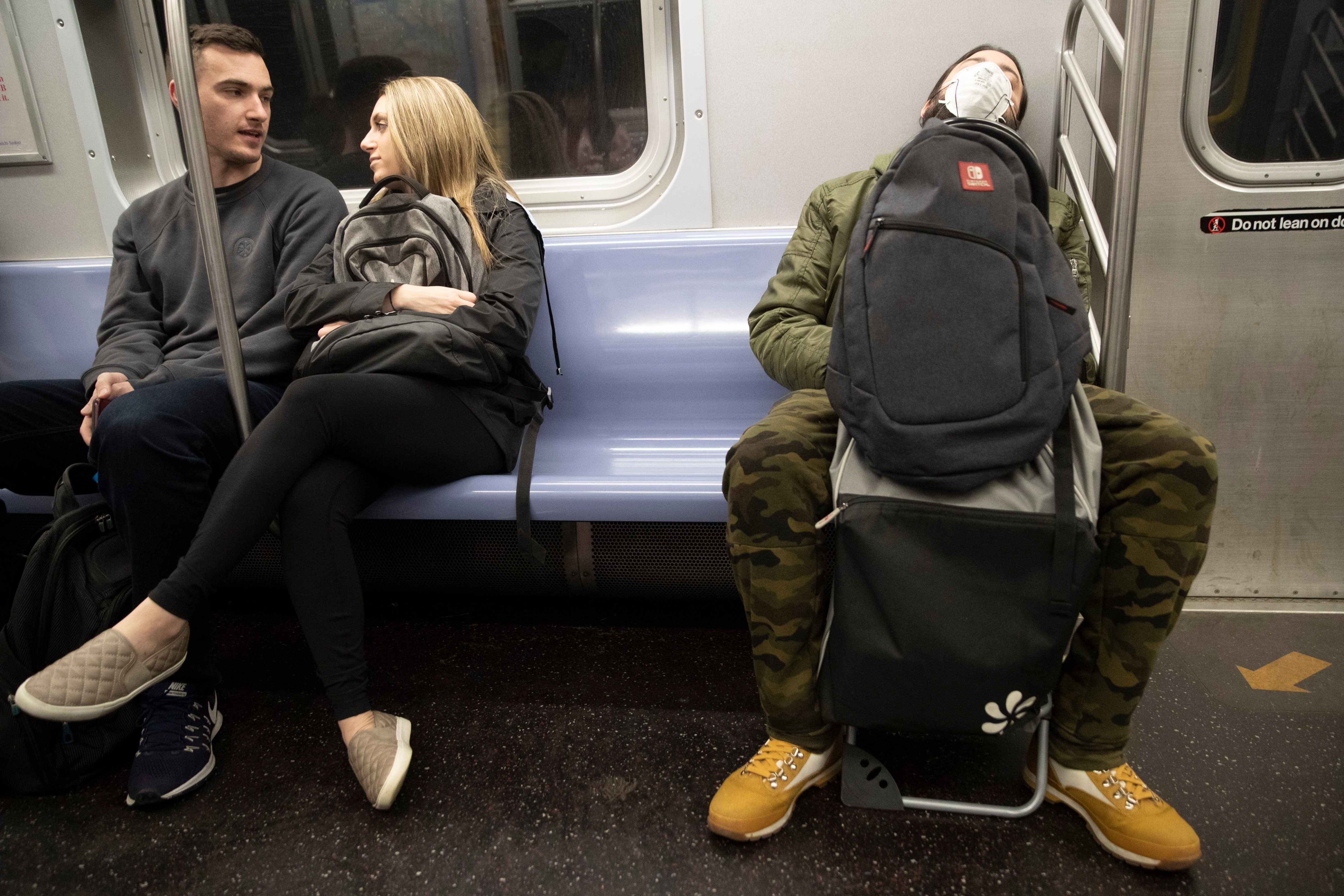 A commuter wears a face mask while riding the subway on March 10, 2020, in New York. (Mary Altaffer—AP)