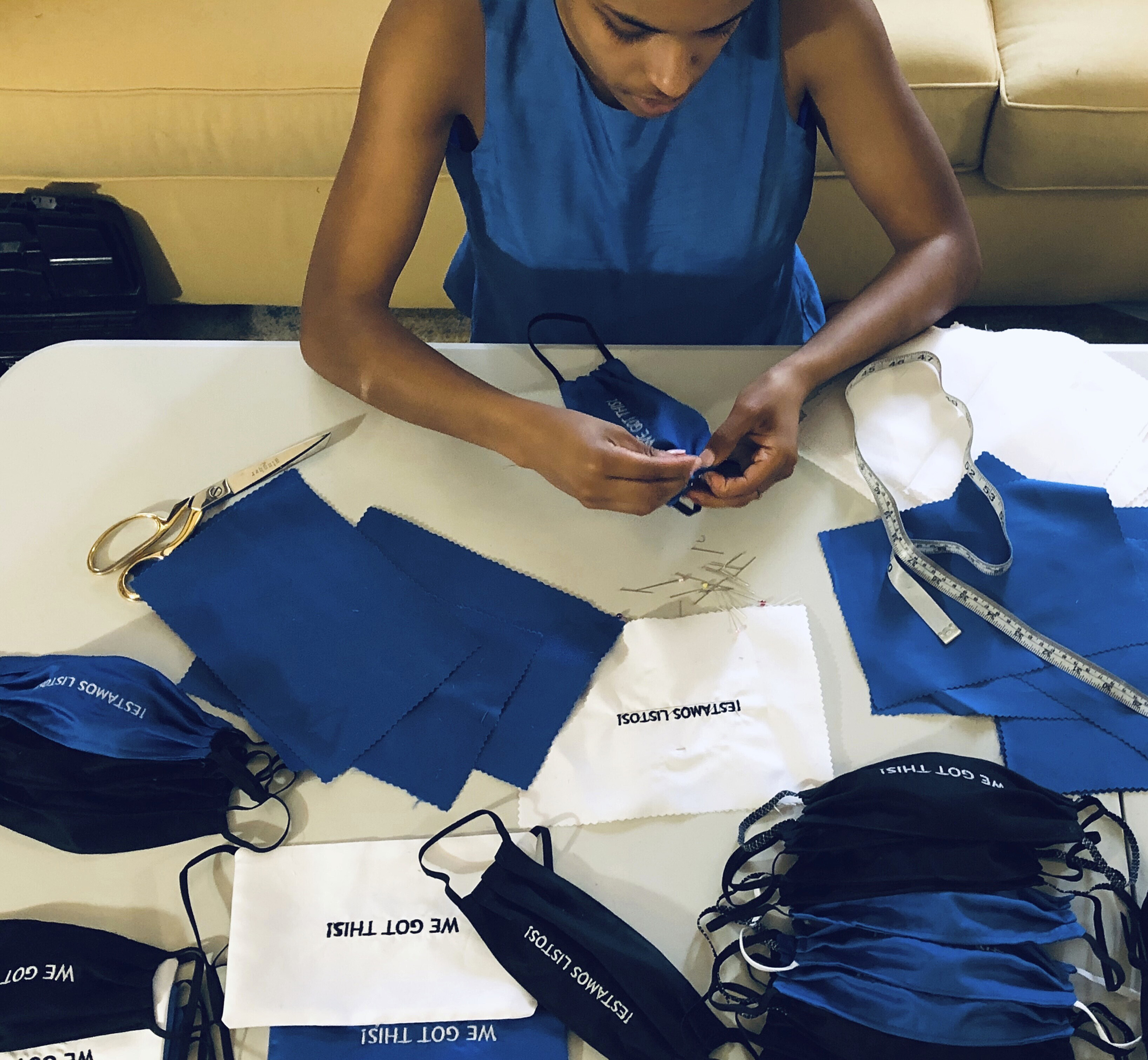 Briana Danyele sews cloth face masks that say "We Got This!" in her mother's living room which will be sent to health care workers in Greer, S.C., on March 22, 2020 (Christina Hunter via AP)