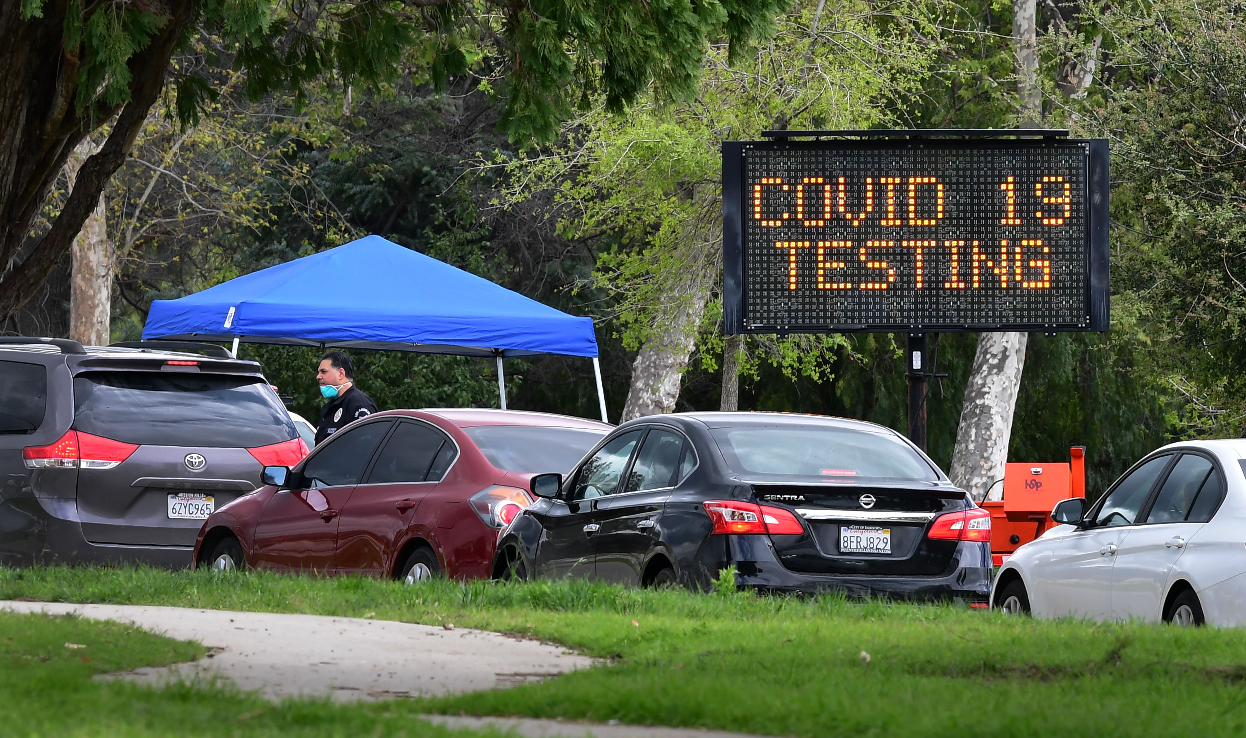 Cars wait to enter a COVID-19 testing center in Pacoima, Calif., on March 25, 2020. (Frederic J. Brown—AFP/Getty Images)
