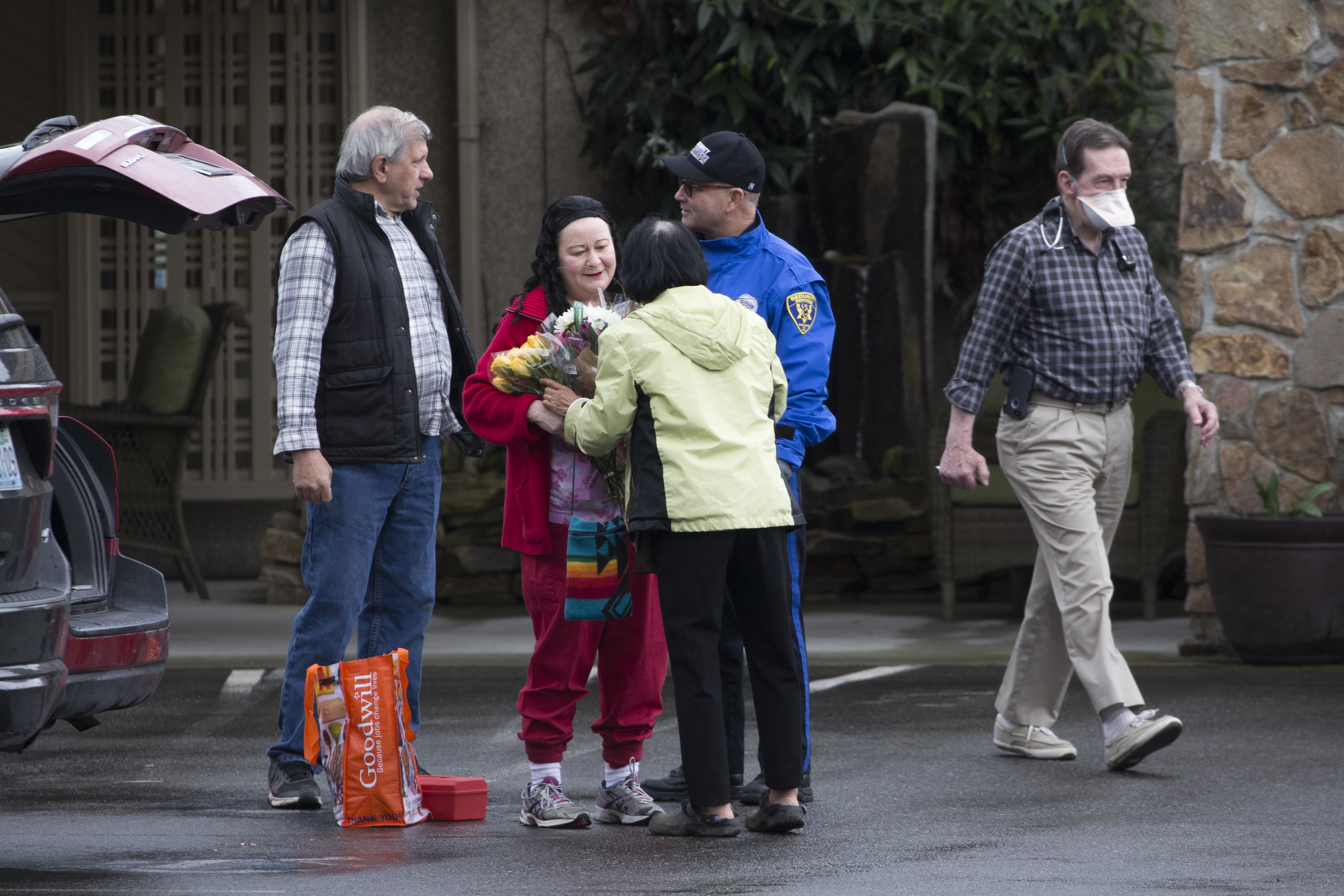 Su Wilson hands flowers to a staff member (in red uniform) to give to her mother, Chun Liu, who is a patient at the Life Care Center nursing home in Kirkland, Washington, on March 6, 2020. (Karen Ducey—Getty Images)