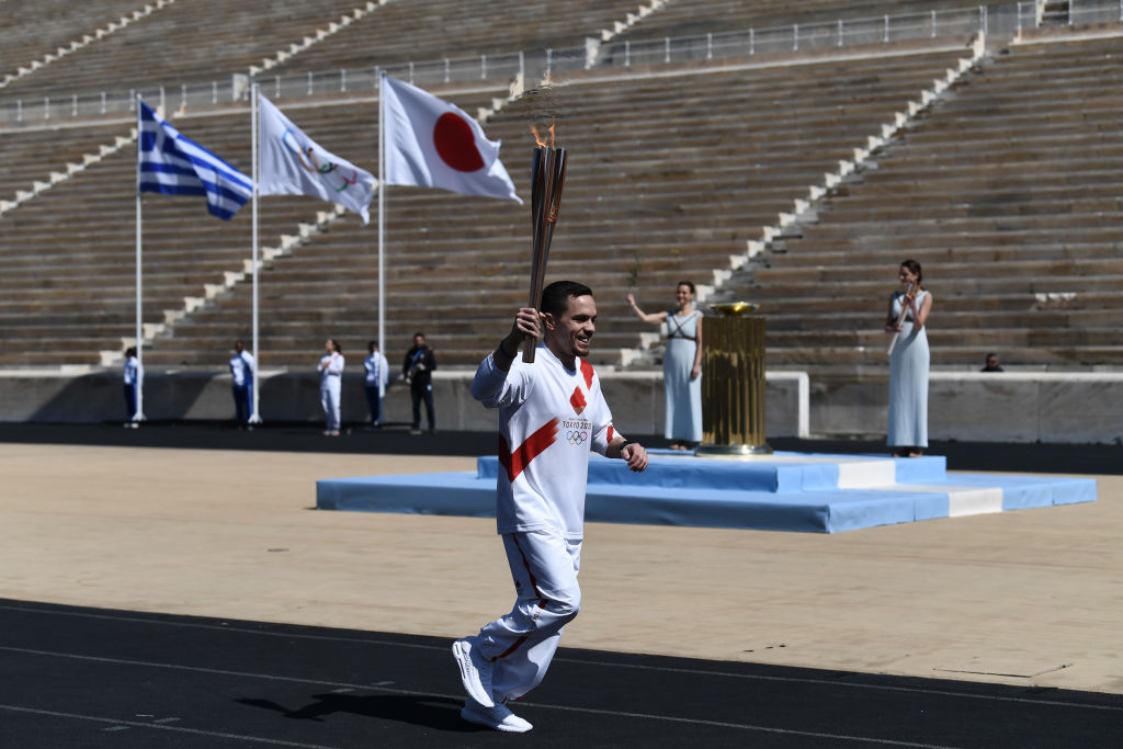 An athlete carries the olympic torch during one of the last relays ahead of the olympic flame handover ceremony for the 2020 Tokyo Summer Olympics in Athens, Greece on March 19, 2020. (ARIS MESSINIS—AFP/ Pool/Anadolu Agency via Getty Images)