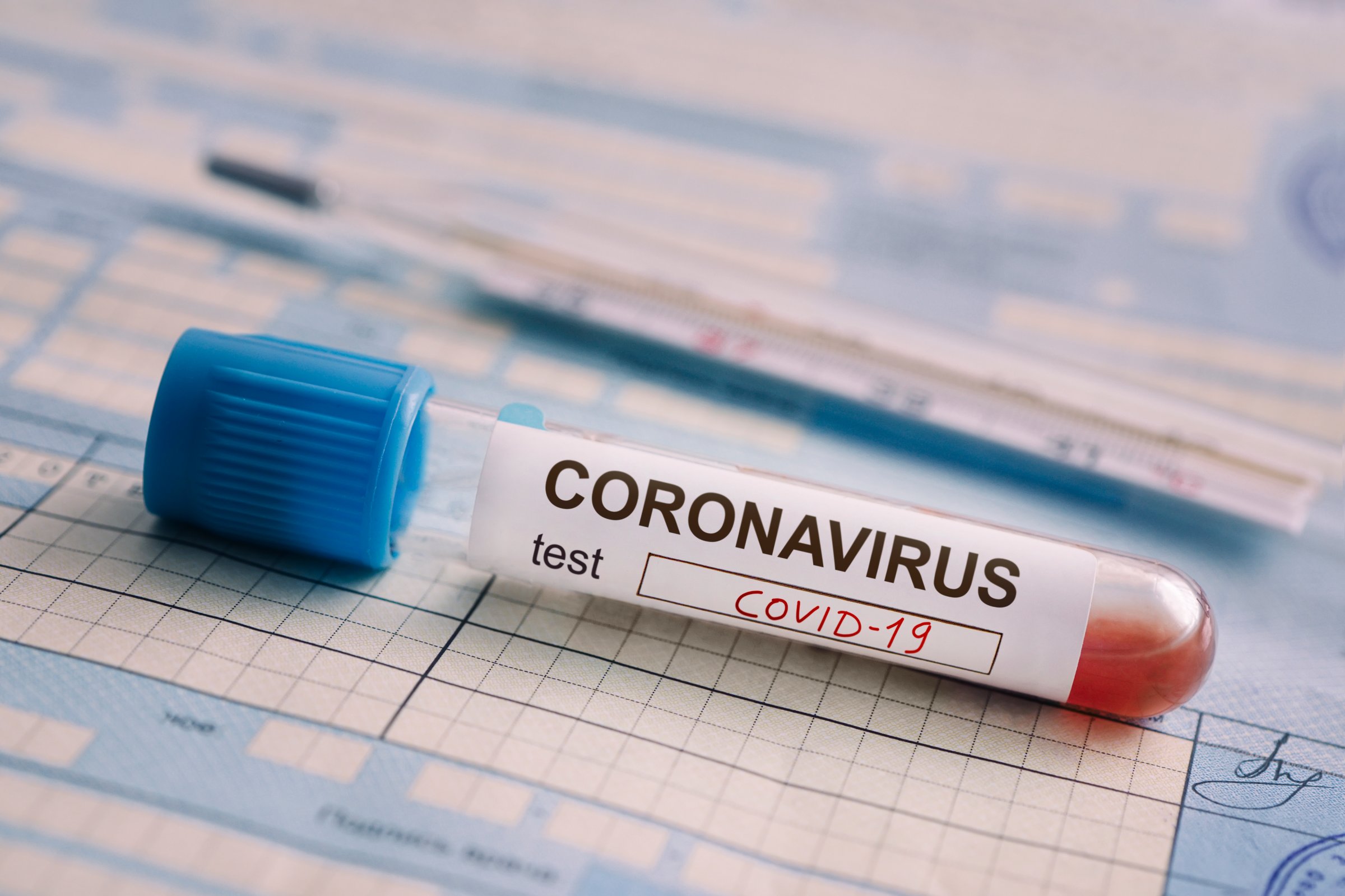 test tube with the blood test is on the table next to the documents. Positive test for coronavirus covid-19. concept of fighting a dangerous Chinese disease.