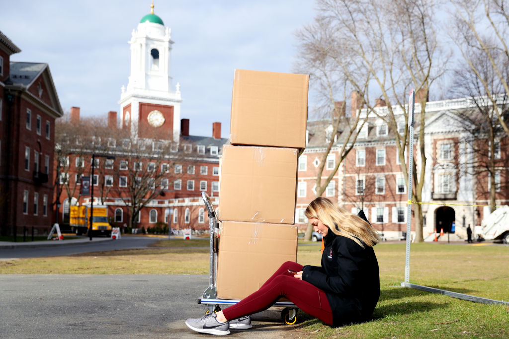 Harvard Sophomore Jordan Di Verniero, 19, sits with her belongings in front of Eliot House before returning home to Ormond Beach, Florida, for the rest of the semester on March 12 in Cambridge, Massachusetts. (Getty Images—2020 Getty Images)