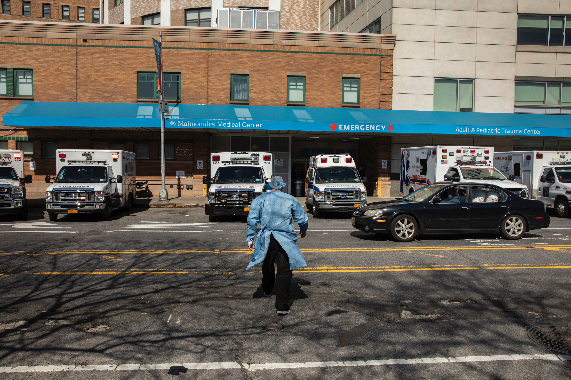 After a break, a technician walks back into Maimonides Medical Center in Brooklyn through the ambulance bay on March 26, 2020.