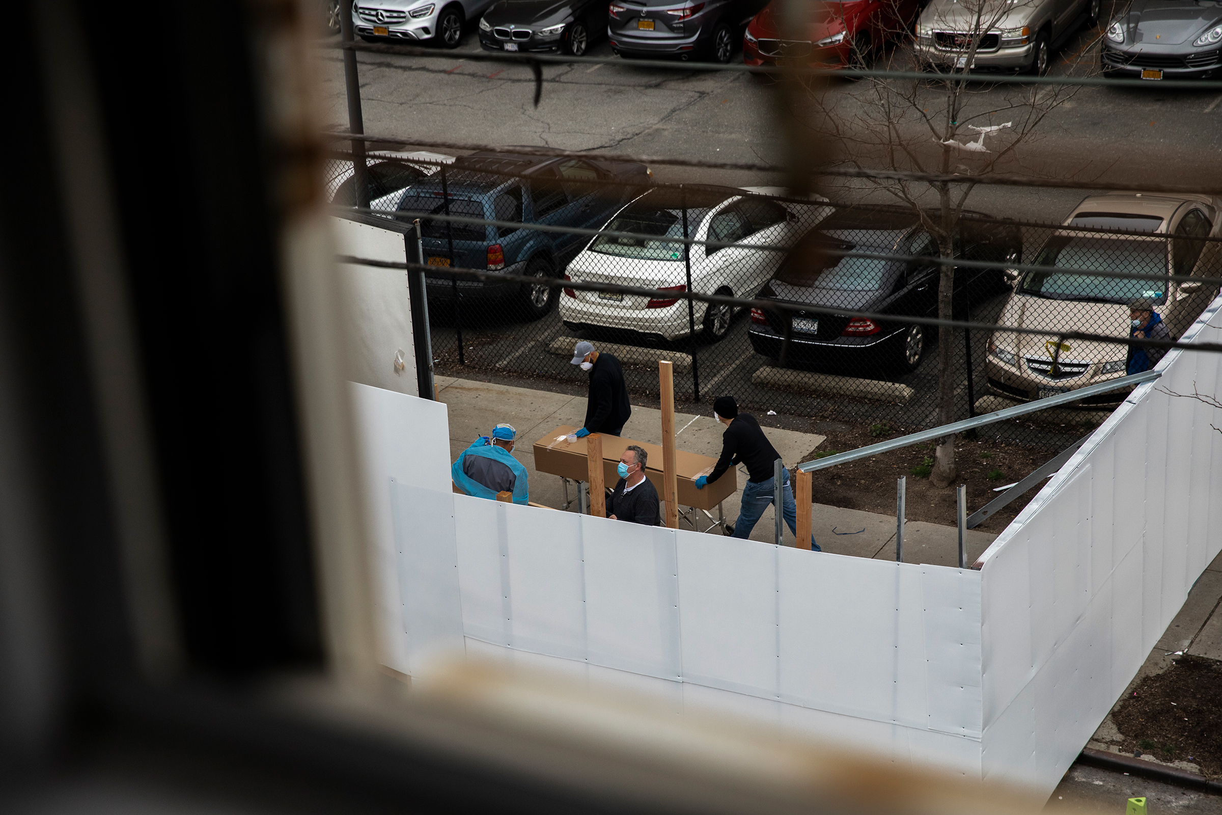 Workers transport a casket-sized box near the morgue set up outside Wyckoff Heights Medical Center in Brooklyn on March 30. (Benjamin Norman for TIME)