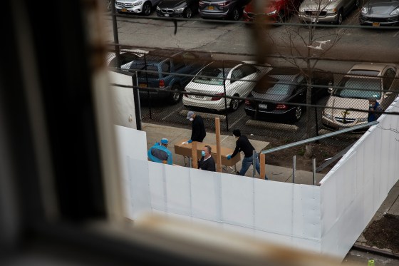Workers transport a casket-sized box near the morgue set up outside Wyckoff Heights Medical Center in Brooklyn on March 30.