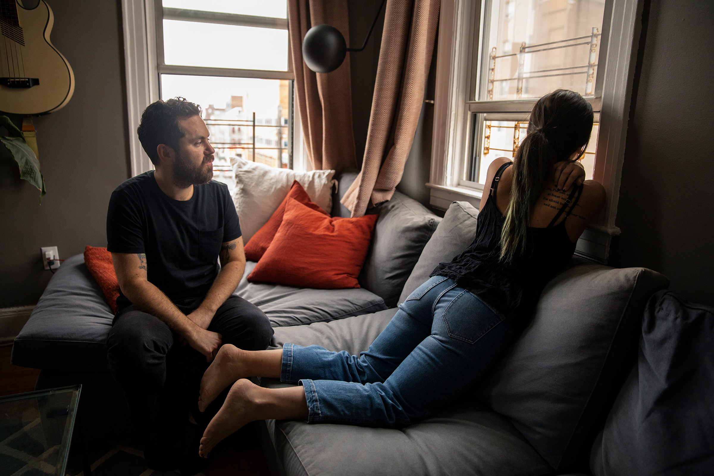Marc Kozlow, 33, and Alix Monteleone, 28, look out their window toward Wyckoff Heights Medical Center on March 30. In one weekend, after a temporary morgue was erected outside, they counted more than a dozen bodies. "I want to know," Monteleone says, referencing the temporary morgue parked nearby. "I want to know the body count." (Benjamin Norman for TIME)