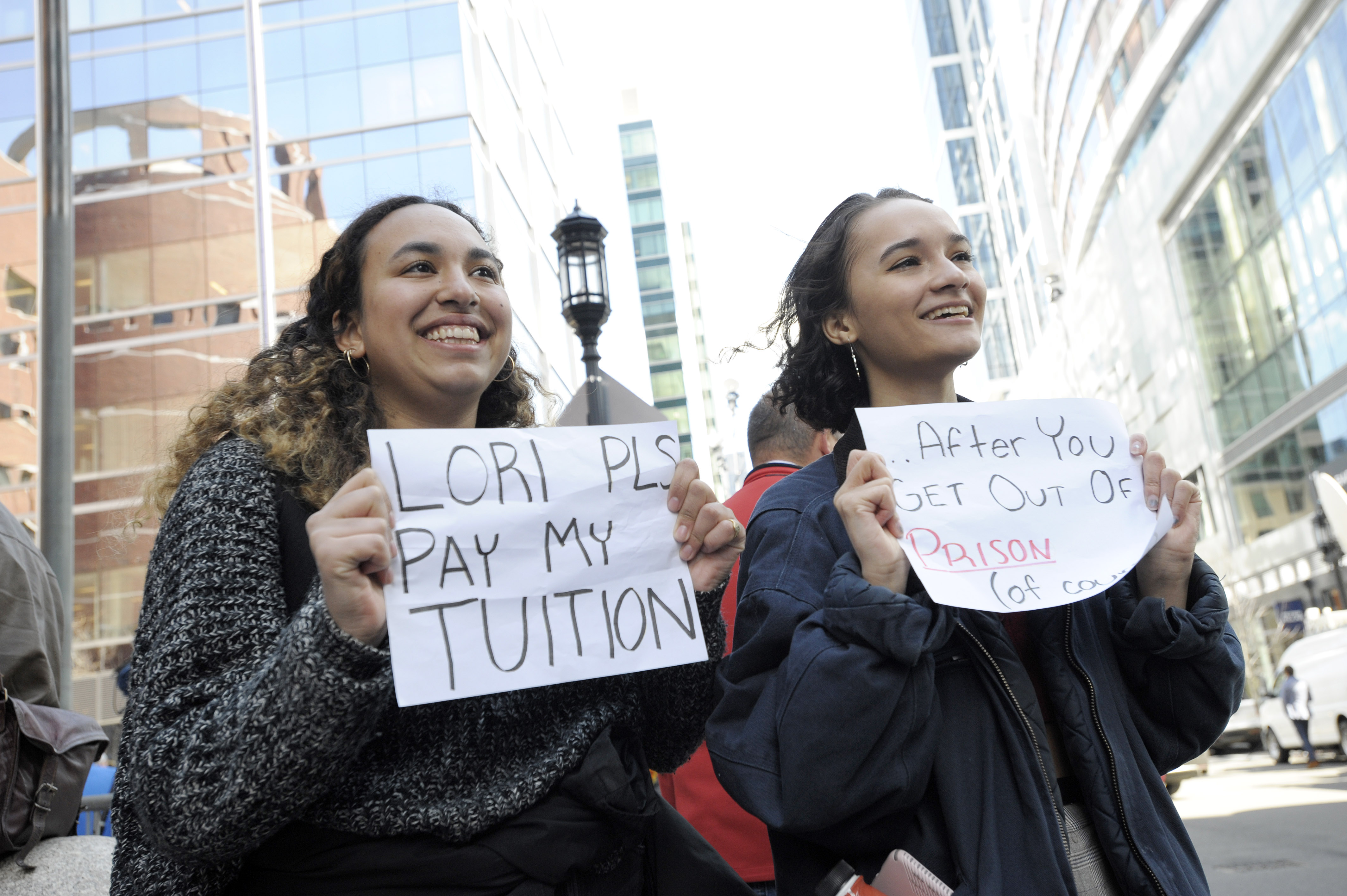 Mackenzie Thomas and Vivi Bonomie hold signs outside federal court in Boston, where actor Lori Loughlin was facing criminal charges related to a college admissions scandal, on April 3, 2019. (Joseph Prezioso—AFP/Getty Images)