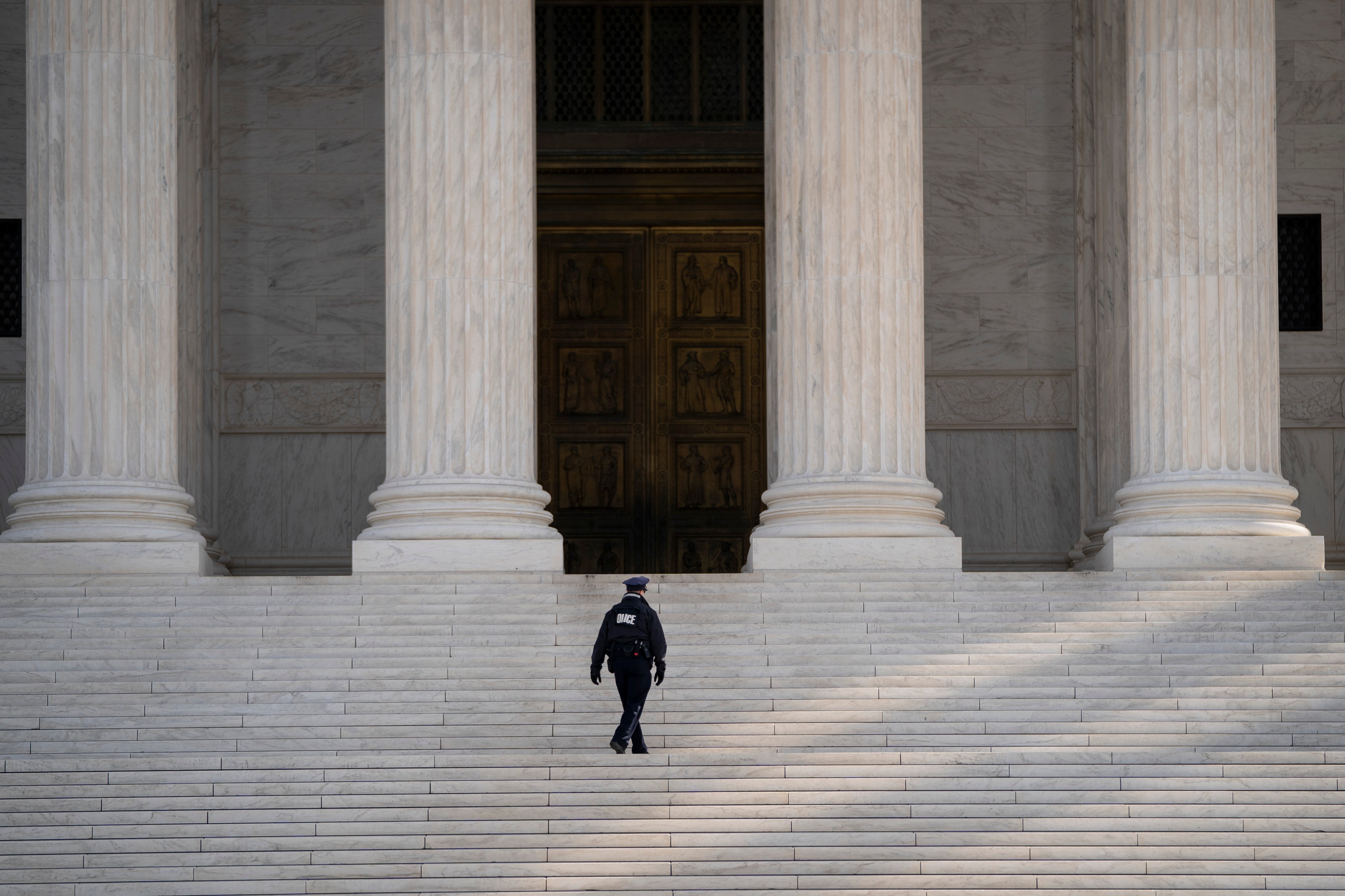 A Supreme Court police officer walks up the steps at the U.S. Supreme Court on March 16, 2020 in Washington, DC. (Photo by Drew Angerer—Getty Images)