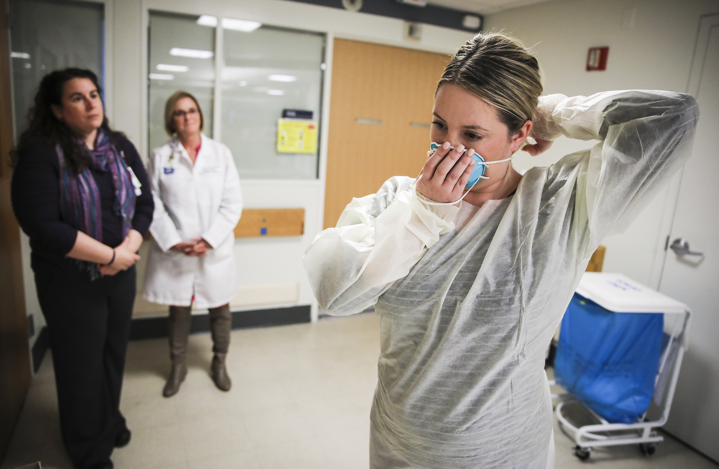 Kaylen Smith demonstrates how to don the protective gear that must be worn when dealing with patients with an infectious disease as Massachusetts General Hospital in Boston prepares for a possible surge in coronavirus patients, on Feb. 27, 2020. (Erin Clark—The Boston Globe via Getty Images)
