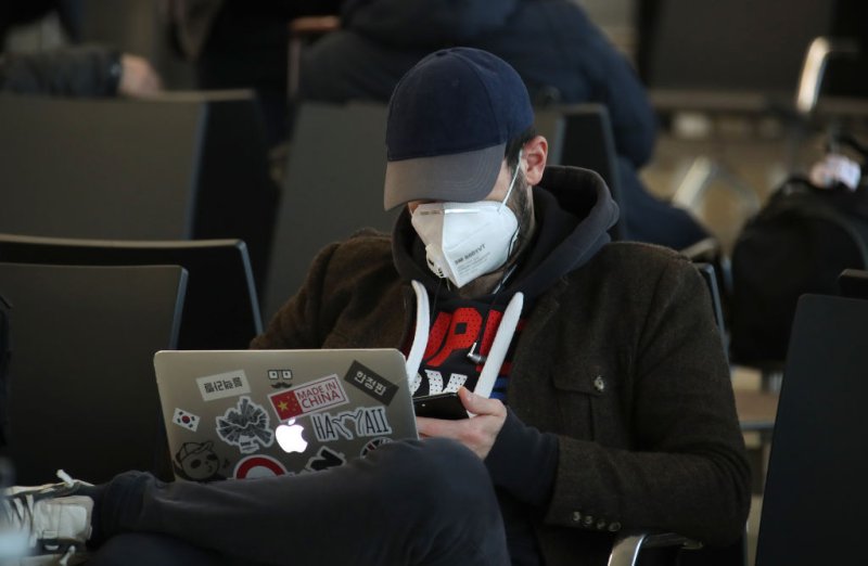 A traveler in a face mask uses a laptop computer at the Sheremetyevo International Airport.
