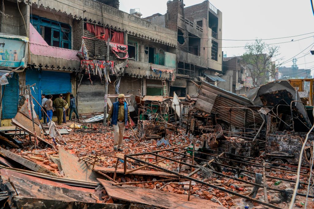 Security personnel patrol near burnt-out and damaged residential premises and shops in New Delhi on February 26, 2020. (Sajjad Hussain/AFP via Getty Images)
