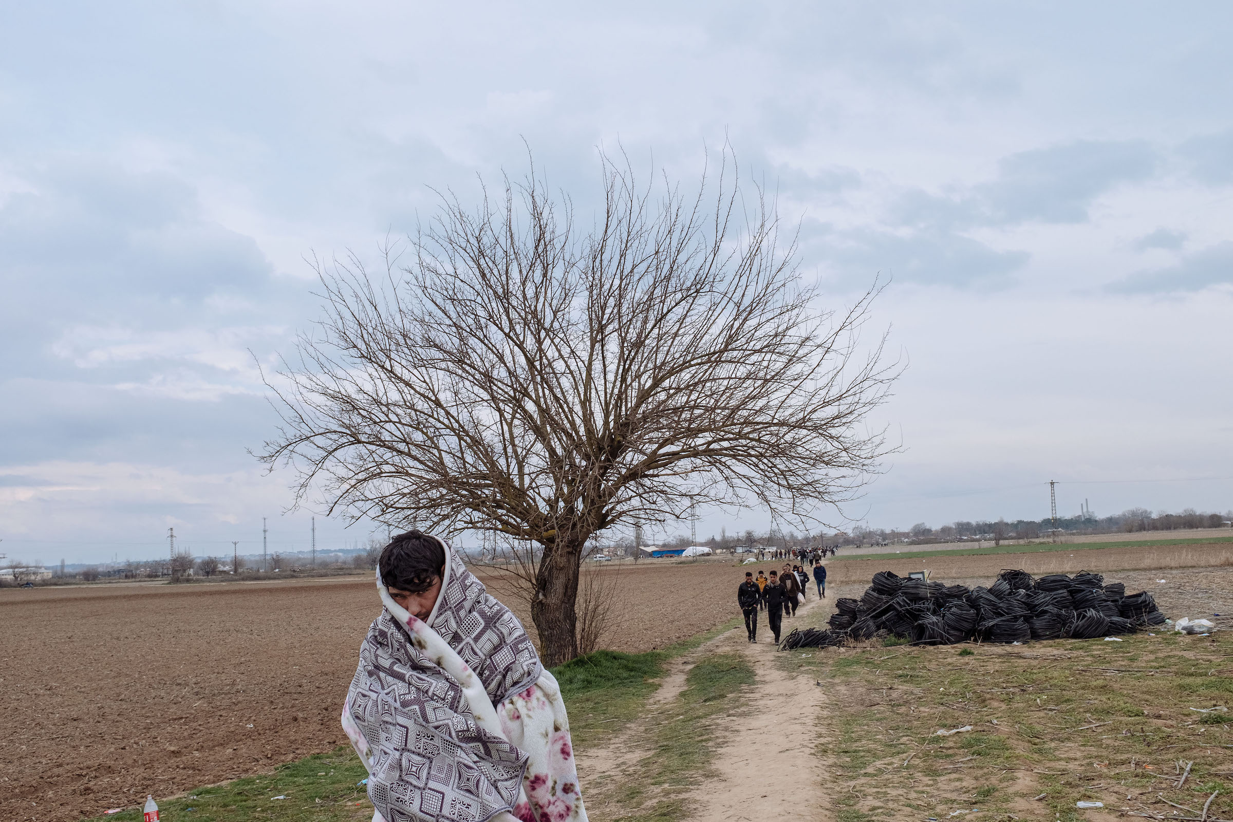 Migrants walk through a field toward the Turkey-Greece border.