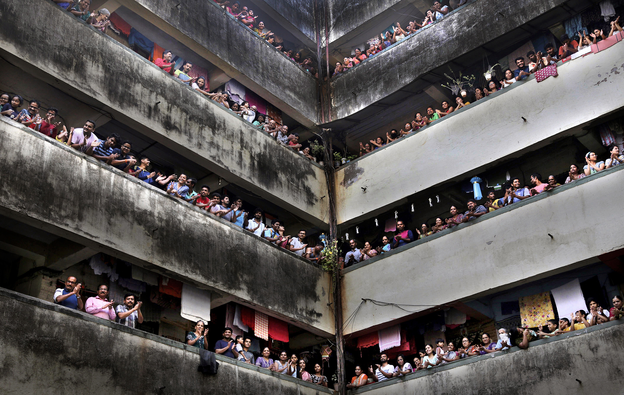 People clap from balconies in show of appreciation to health care workers at a chawl in Mumbai, India, on March 22, 2020. (Rafiq Maqbool—AP)