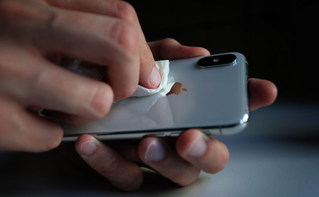 A young man disinfects his smartphone with a paper towel and disinfectant. (dpa/picture alliance via Getty I&mdash;(c) Copyright 2020, dpa (www.dpa.de). Alle Rechte vorbehalten)