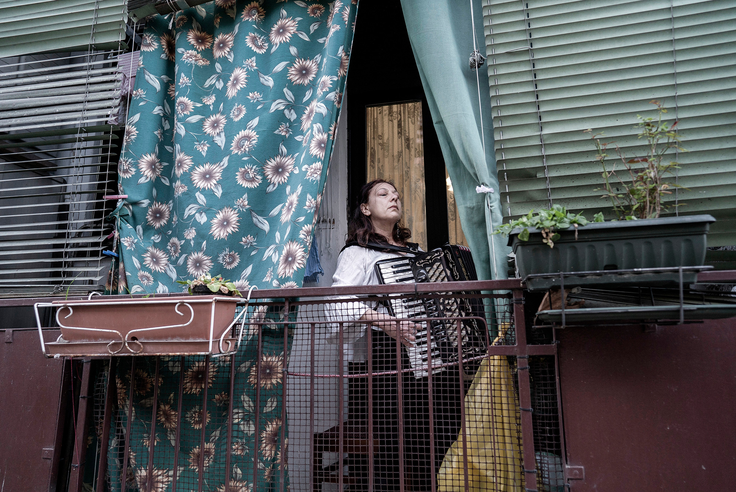 Citizens of Milan take to their balconies on March 13 to serenade their neighbors; 10 days later, Italy had nearly 70,000 confirmed cases of COVID-19 and almost 7,000 dead (Alessandro Grassani—The New York Times/Redux)