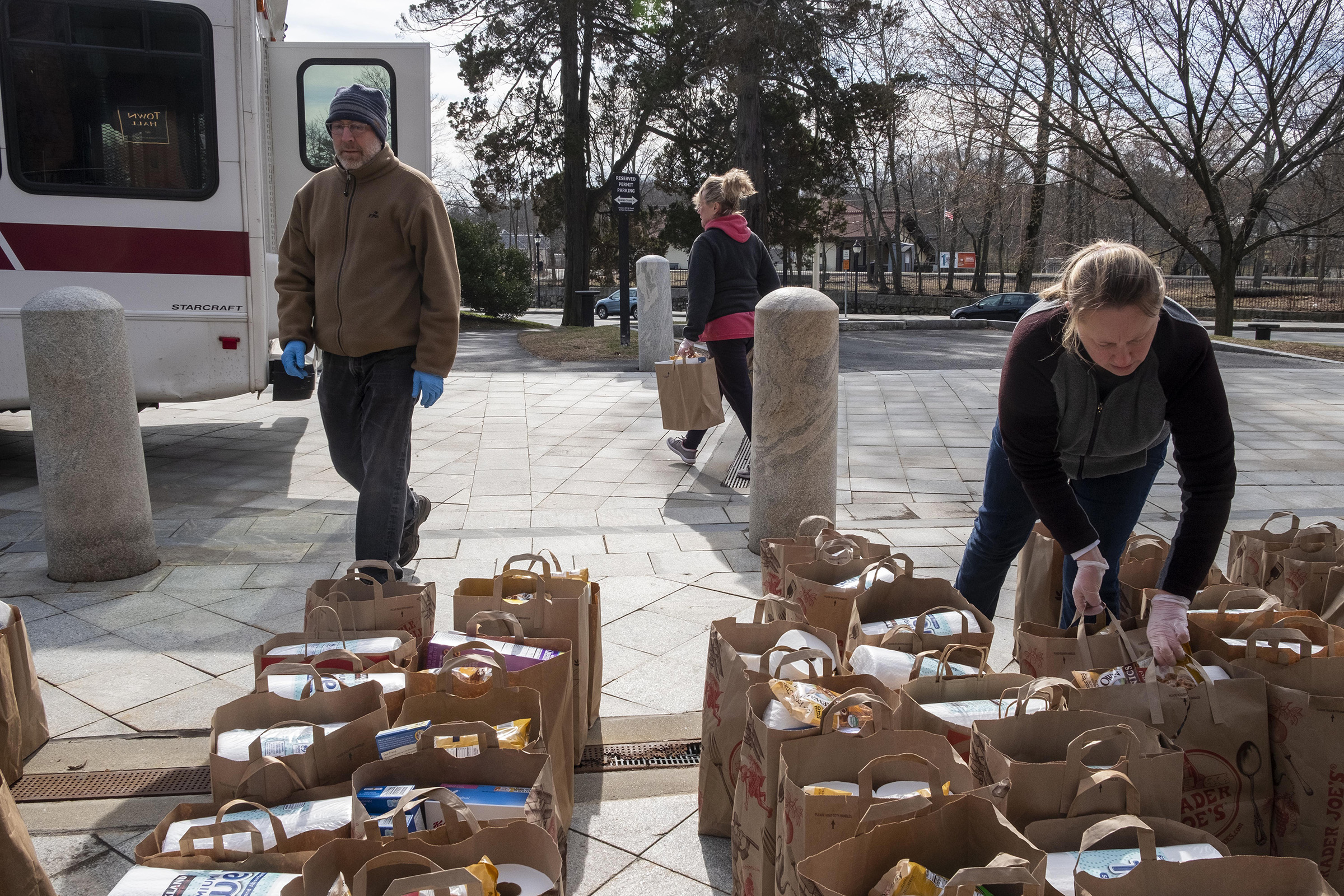Volunteers move bags of nonperishable food and supplies into a Belmont Council on Aging bus as part of distribution to senior citizens in need in Belmont, Mass. (M. Scott Brauer—Redux)