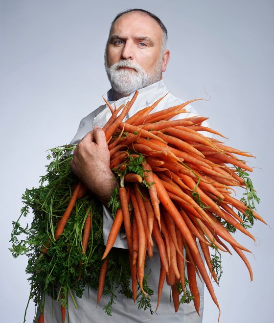 Chef JosÃ© AndrÃ©s poses for a portrait while holding a large bundle of carrots