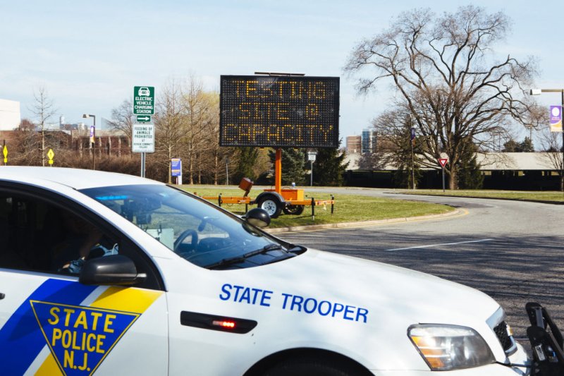A New Jersey State Police vehicle drives in front of an electronic sign that reads Testing Site At Capacity outside a drive-through coronavirus testing facility at Bergen Community College in Paraumus, New Jersey, U.S., on Friday, March 20, 2020.