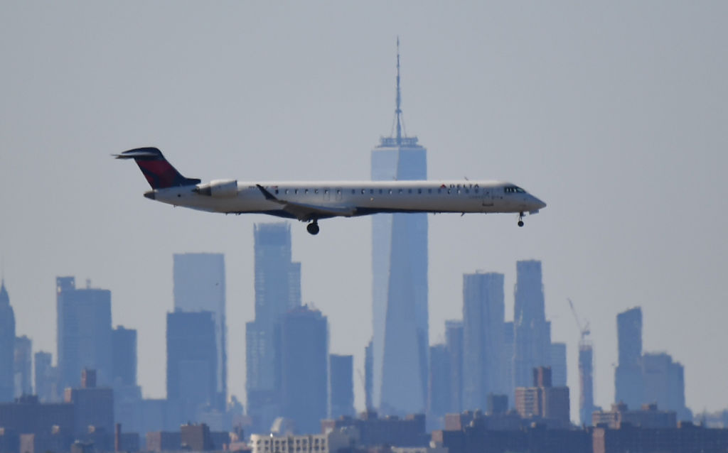 A plane from Delta Air Lines is seen above the skyline of Manhattan before it lands at JFK airport on March 15, 2020 in New York City. (Johannes Eisele—AFP/Getty Images)