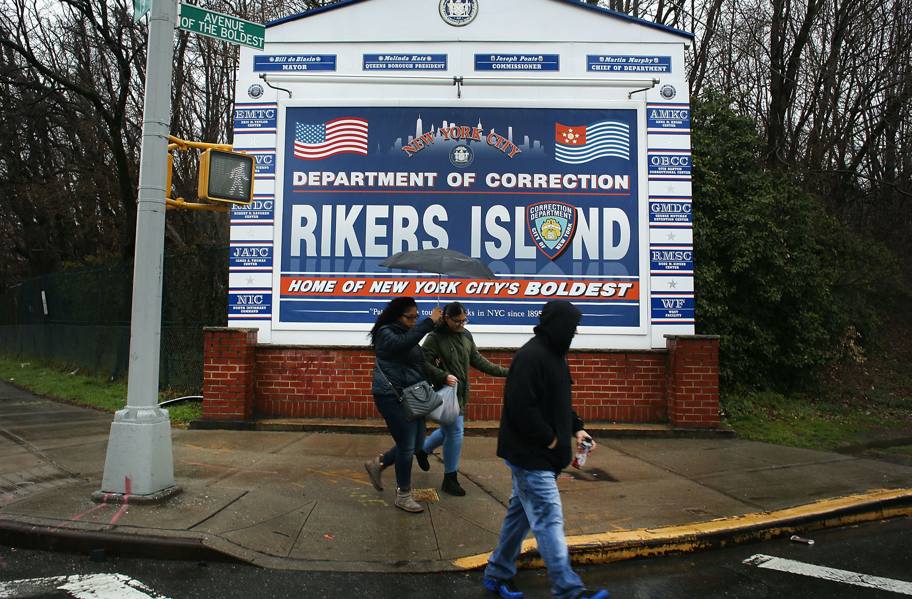 People walk by a sign at the entrance to Rikers Island on March 31, 2017 in New York City. (Spencer Platt—Getty Images)