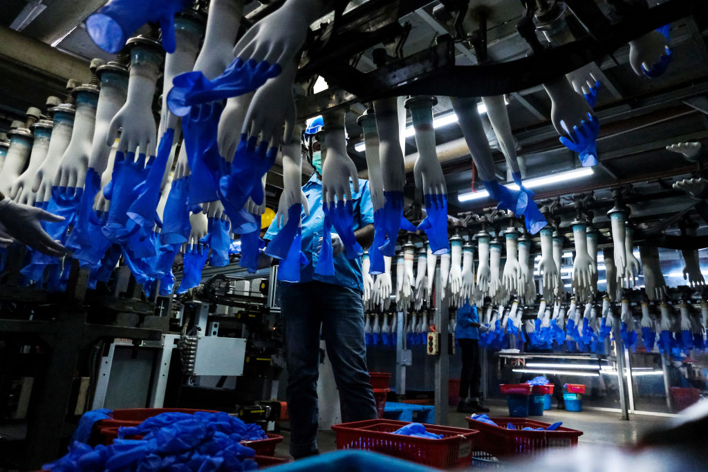 An employee monitors latex gloves on hand-shaped molds moving along an automated production line at a Top Glove Corp. factory in Selangor, Malaysia on Feb. 18, 2020. (Samsul Said&mdash;Bloomberg/Getty Images)