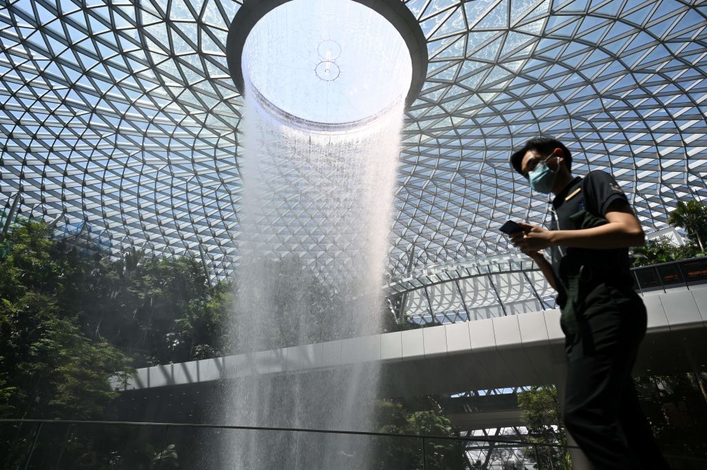 A man wearing a facemask walks past the Rain Vortex display at the airport in Singapore on Feb. 27, 2020. (ROSLAN RAHMAN—AFP/Getty Images)