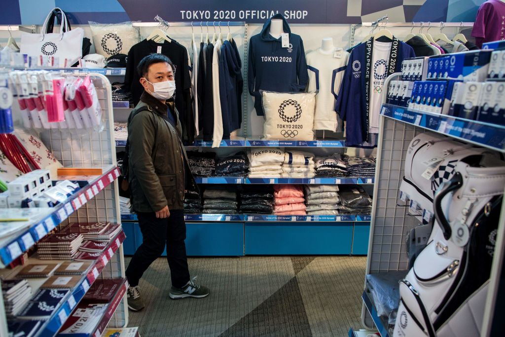 A man wearing a face mask, amid concerns over the spread of the COVID-19 novel coronavirus, visits a Tokyo 2020 official shop in Tokyo on March 25, 2020, the day after the historic decision to postpone the 2020 Tokyo Olympic Games. (Behrouz Mehri–AFP/Getty Images)