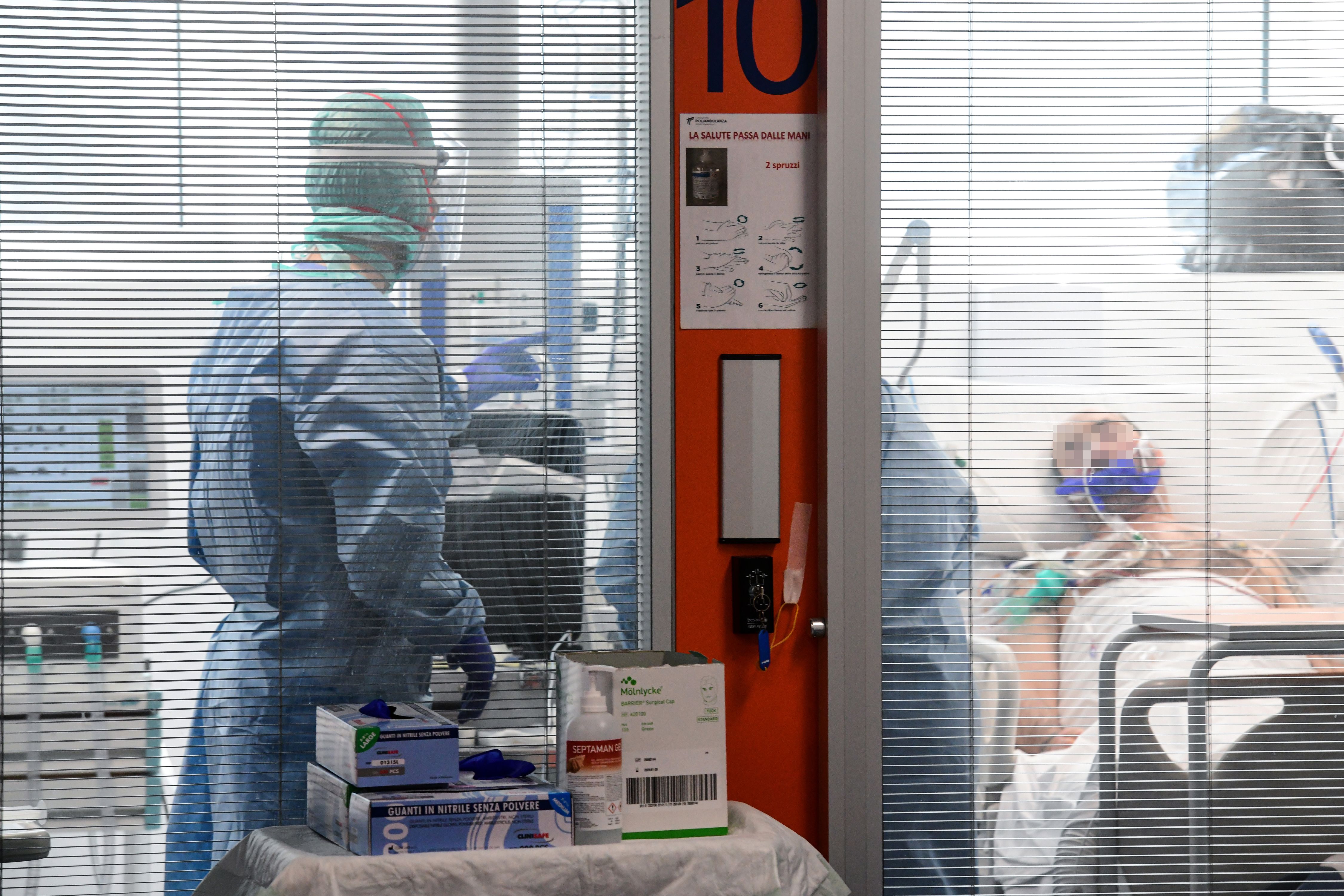Medical workers wearing a face make and protection gear tend to a patient inside the new coronavirus intensive care unit of the Brescia Poliambulanza hospital, Lombardy, on March 17, 2020. (Piero Cruciatti—AFP/Getty Images)
