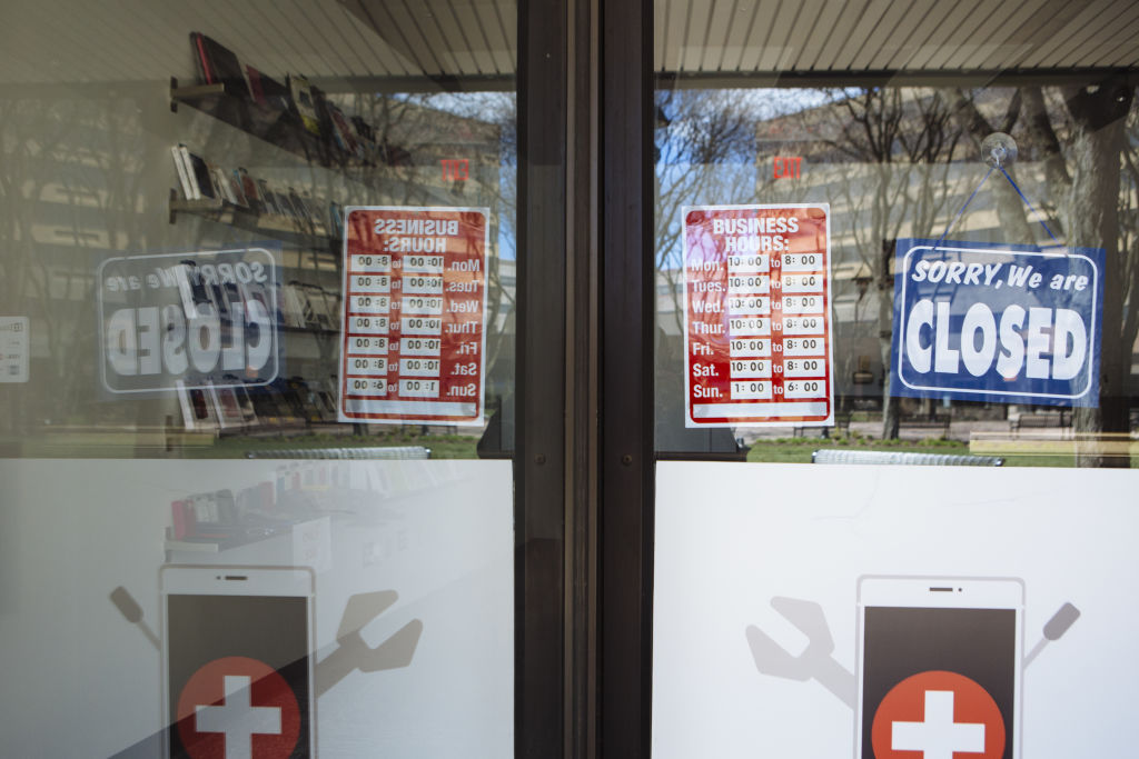 A "Closed" sign hangs in the window of a phone repair shop at The Plaza at Harmon Meadow in Secaucus, New Jersey, U.S., on April 2, 2020. (Angus Mordant—Bloomberg/Getty Images)