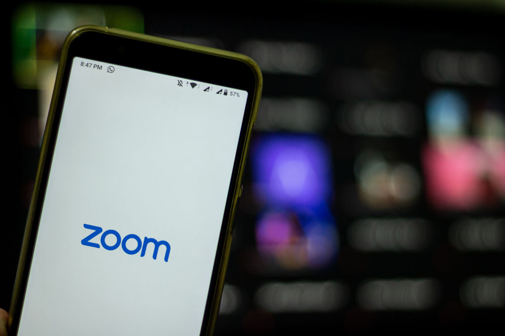 Logo of Zoom, the video conferencing application services company, is seen with the group chat in the back of it in Yogyakarta, Indonesia on April 3, 2020. (Rizqullah Hamiid—NurPhoto/Getty Images)