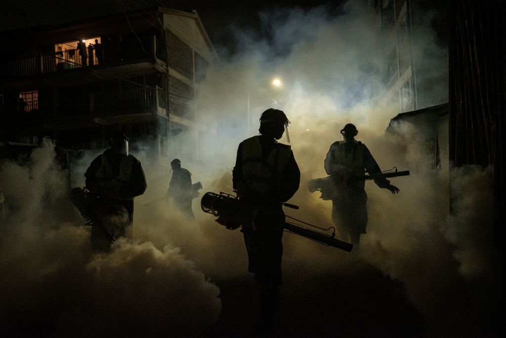 Volunteers from Sonko Rescue Team, an NGO privately funded by Nairobi Governor Mike Sonko, fumigate a street to curb the spread of COVID-19 during a joint operation with Nairobi county during a 7pm-5am curfew at a residential area in Nairobi, Kenya, on April 6, 2020. (Yasuyoshi Chiba—AFP via Getty Images)