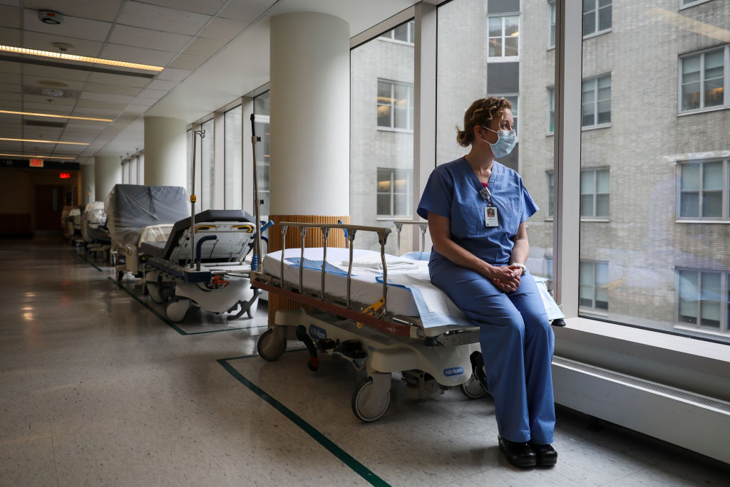 Christine McCarthy, a nurse for over 20 years and a palliative nurse for the past year, sits for a portrait on an empty hospital bed at Massachusetts General Hospital in Boston on Apr. 2. (Erin Clark—Boston Globe/Getty Images)