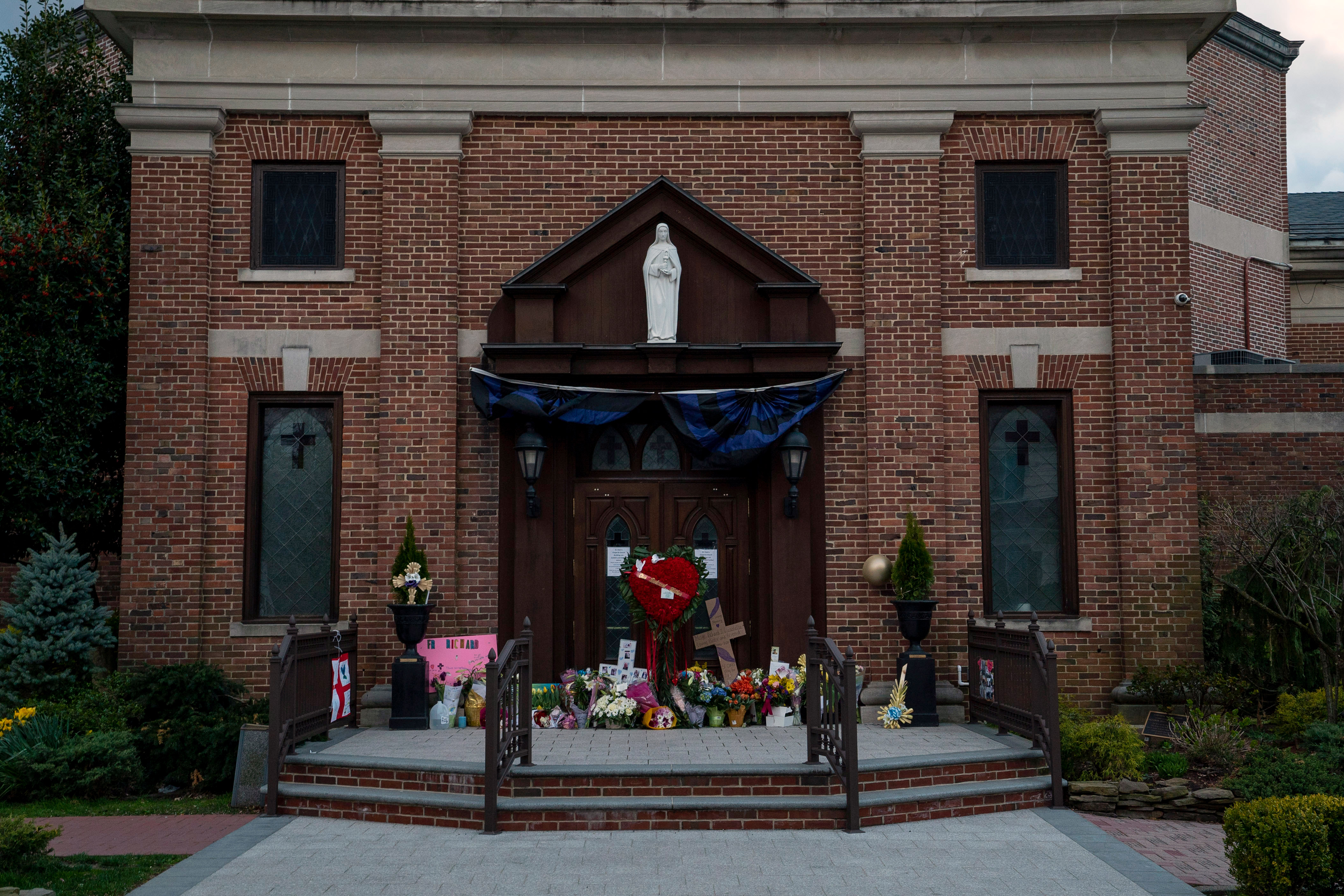 A memorial for Monsignor Richard Guastella, who died from Covid-19 on Thursday,  outside the doors of St. Clare Catholic Church in Staten Island, N.Y., on April 10, 2020. (Paul Moakley for TIME)
