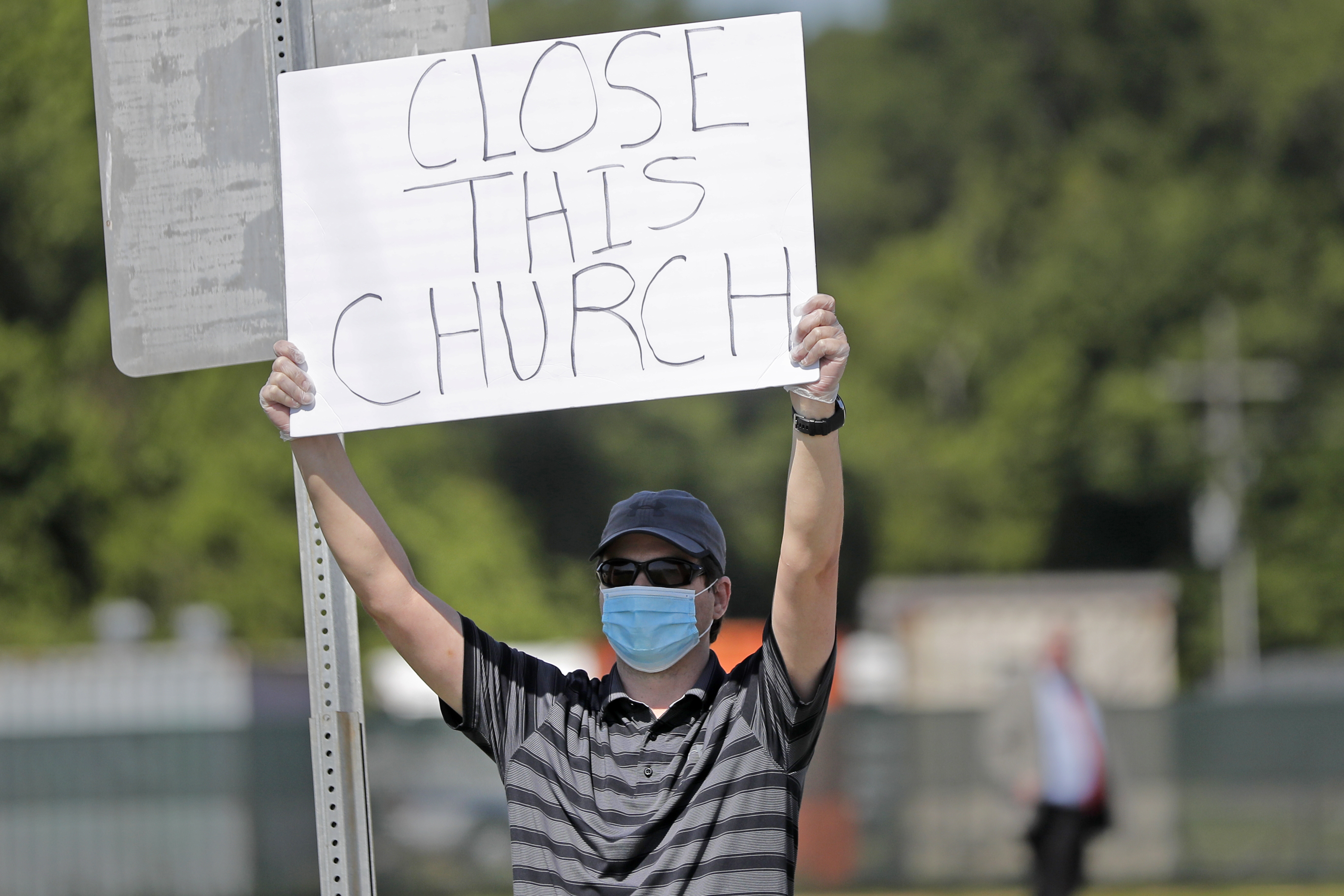 Protestor Trey Bennett holds a sign outside the East Baton Rouge Parish while waiting for  Pastor Tony Spell to post bond in Baton Rouge, La. on April 21, 2020. (Gerald Herbert—AP)