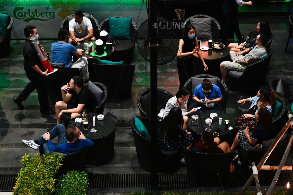 Waiters wearing facemasks as a preventive measure against the spread of the COVID-19 coronavirus serve customers at a hotel bar in Bangkok on March 17, 2020. (Romeo Gacad–AFP/Getty Images)