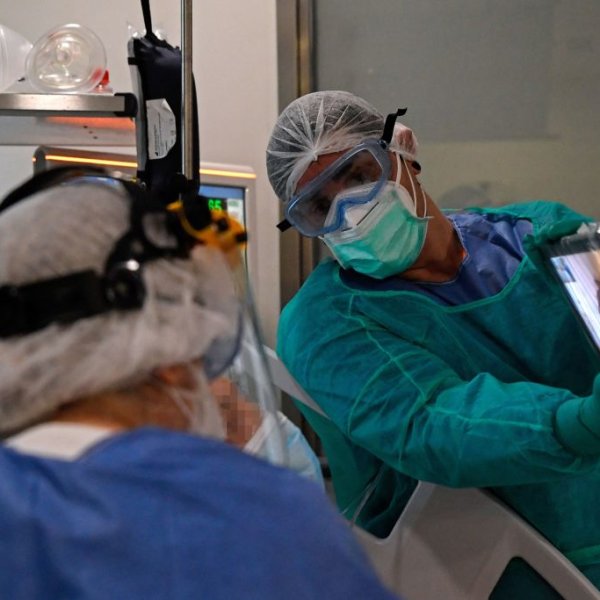 Healthcare workers hold a tablet in front of a COVID-19 coronavirus patient during a video call with relatives at the Intensive Unit Care (ICU) of the Ramon y Cajal Hospital in Madrid on April 14, 2020.