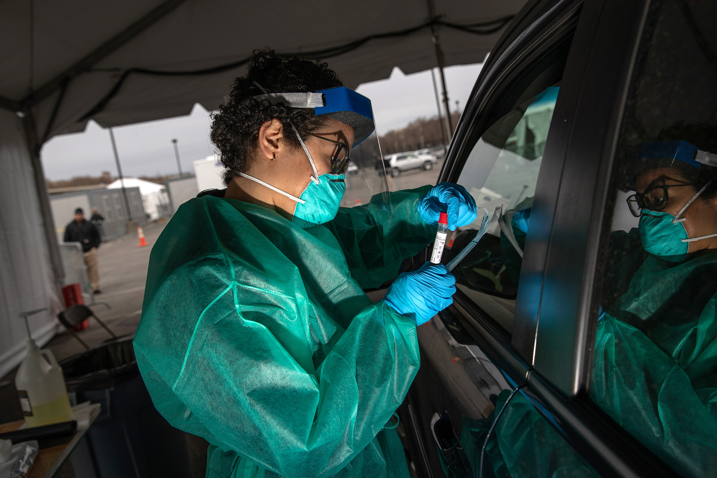 A health worker handles a coronavirus swab test at a drive-thru testing center for COVID-19 at Lehman College on in the Bronx, N.Y., March 28, 2020. (John Moore—Getty Images)