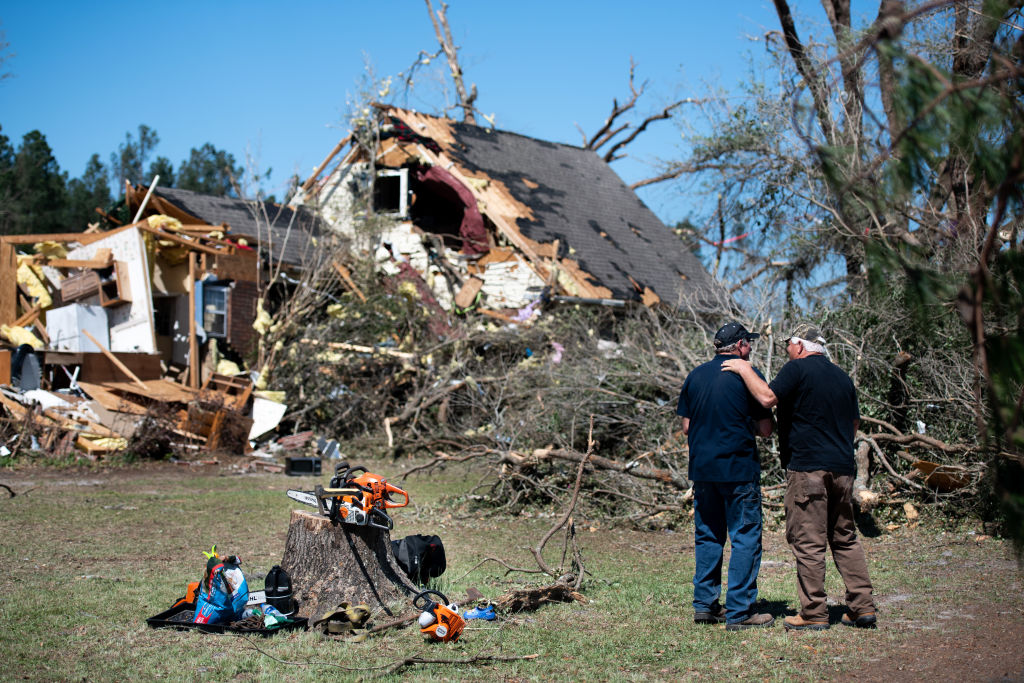 Two men talk in front of a home destroyed by a tornado on April 13, 2020 near Nixville, South Carolina. (Sean Rayford — Getty Images)