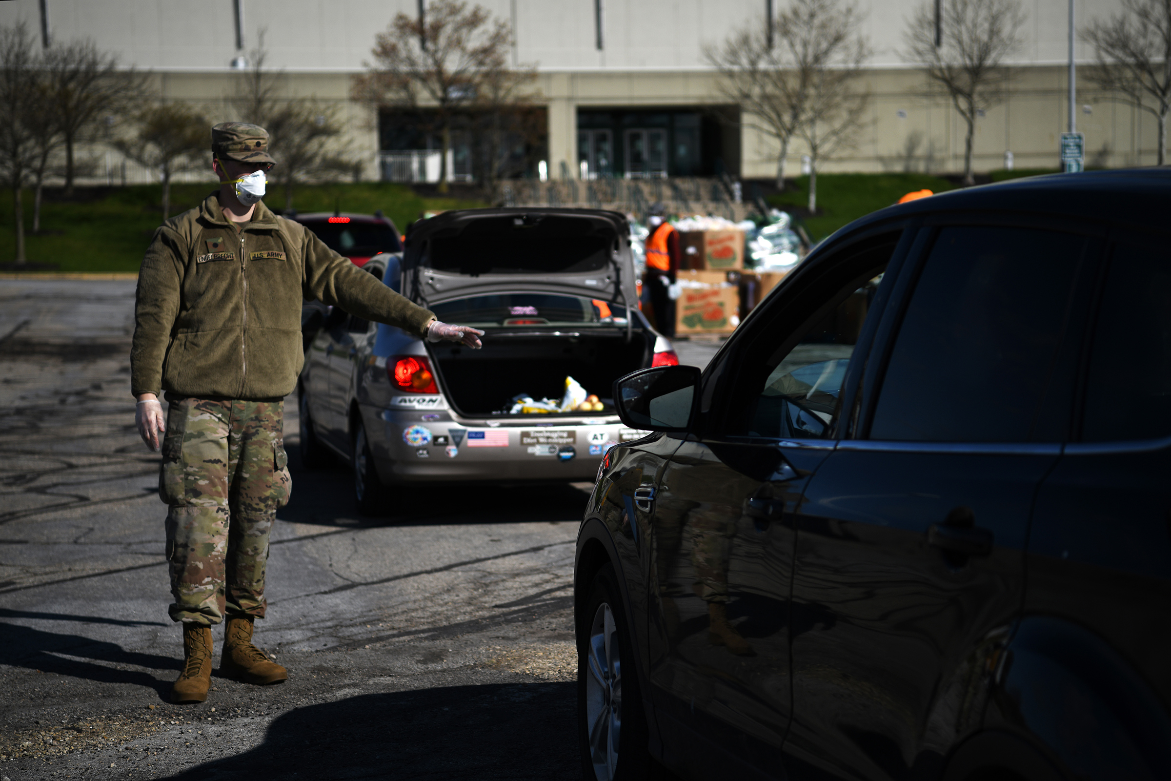 A soldier directs traffic during a drive-thru food distribution event at Wright State University's Nutter Center in Fairborn, Ohio, on April 21, 2020. (Tech Sgt. Shane Hughes—U.S. Air National Guard.)