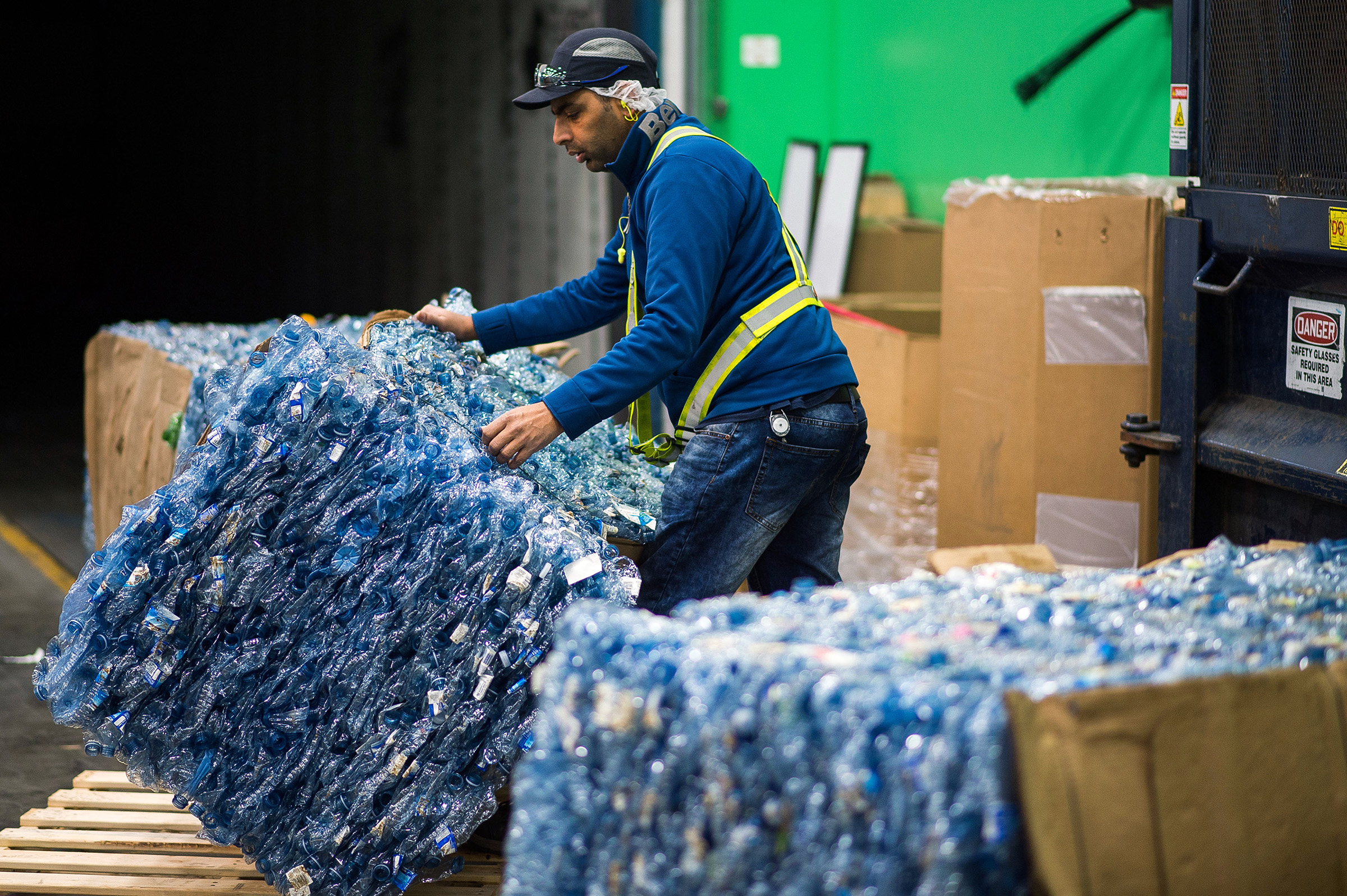 A worker moves a bundle of crushed plastic water bottles to be shipped to the Ice River Springs Water Co. Inc. recycling facility in Chilliwack, Canada, on Nov. 18, 2019. (James MacDonald—Bloomberg via Getty Images)