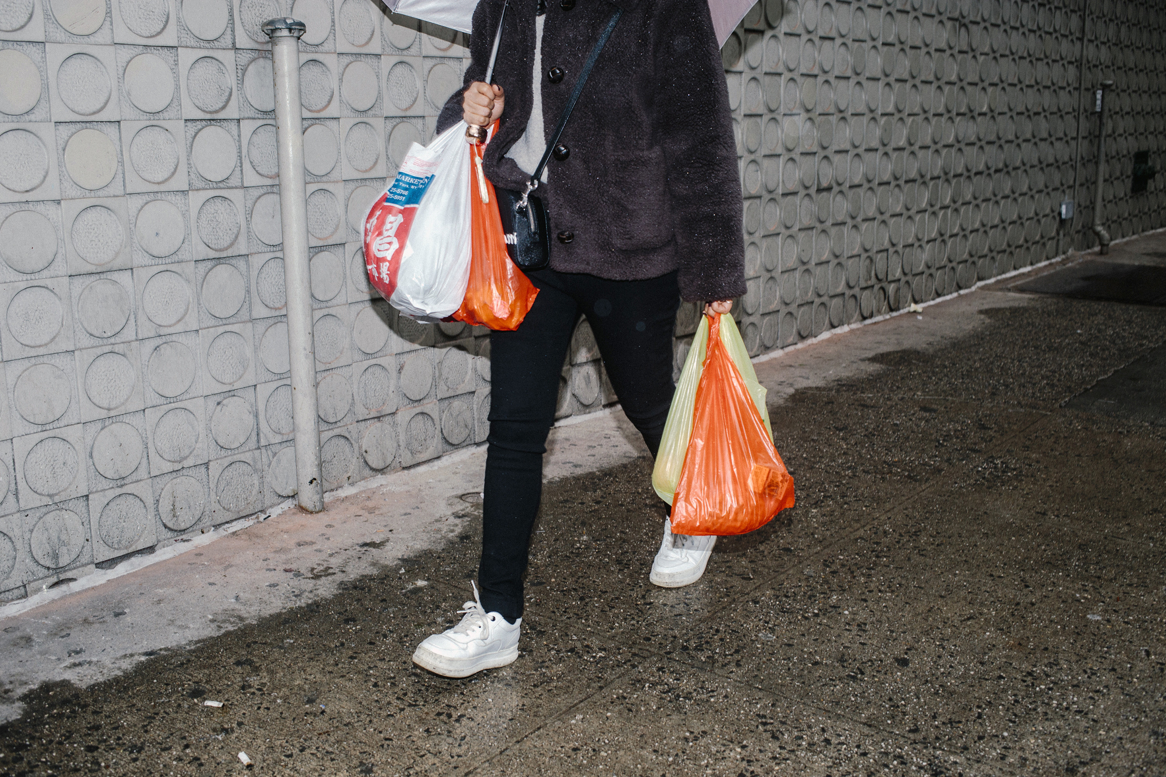 A woman carries plastic bags in New York on Feb. 25, 2020. (Mark Abramson/The New York Times)