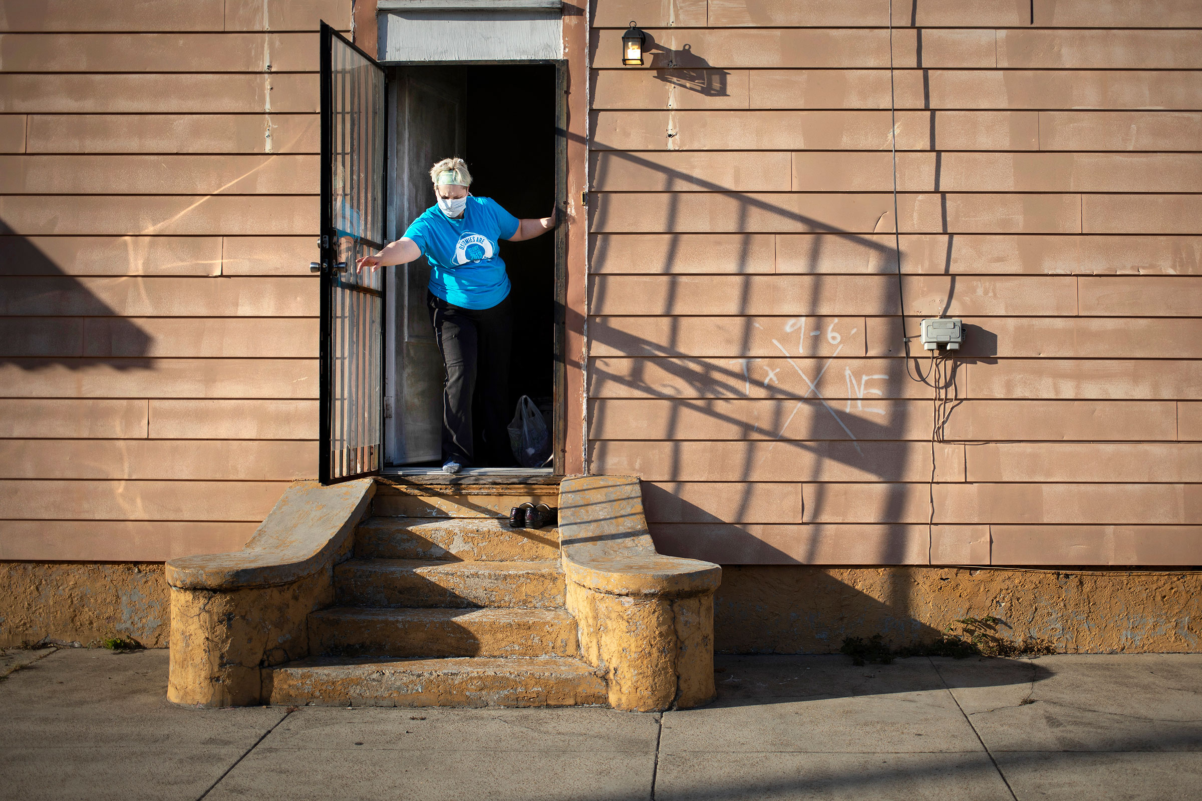 Laurie Halbrook leaves her shoes outside and closes the side door at her house after a shift working as a nurse on April 3, 2020. (Kathleen Flynn for TIME)