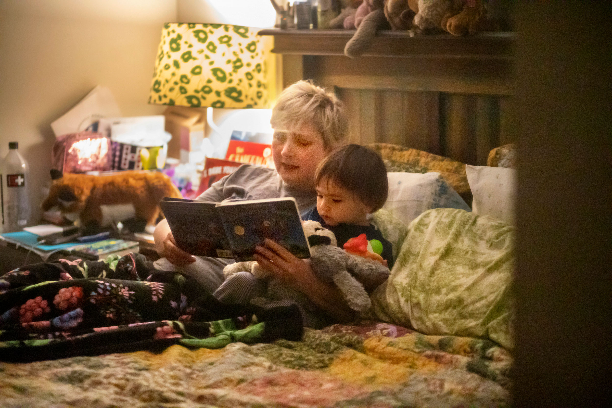 Laurie Halbrook is seen through a window reading a bedtime book to her eighteen month old son Jack, at their home in New Orleans. (Kathleen Flynn for TIME)