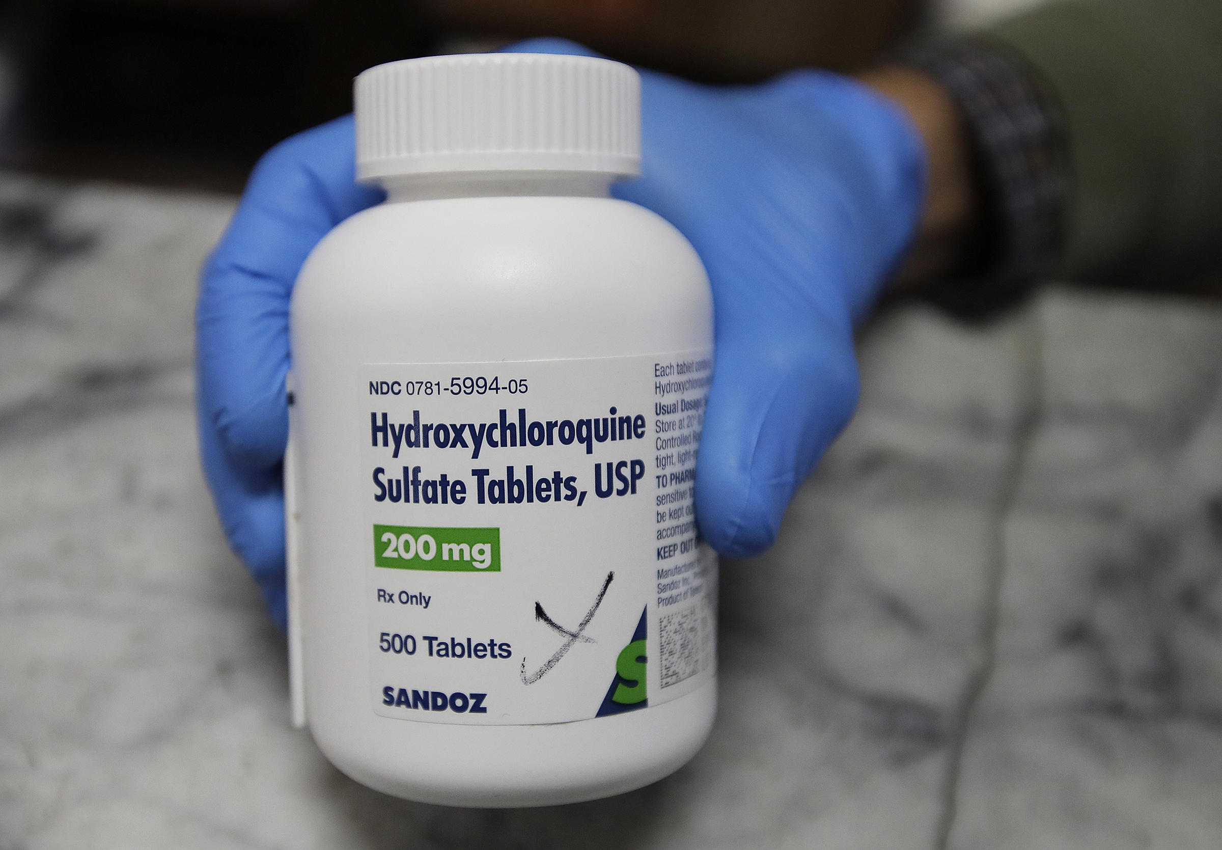 A pharmacist shows a bottle of the drug hydroxychloroquine on April 6, 2020, in Oakland, Calif. (Ben Margot—AP)