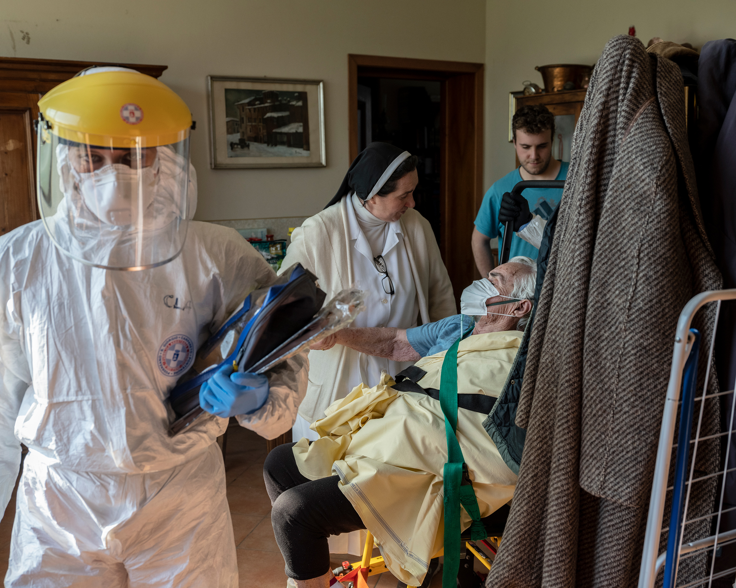 After an assessment by health workers on the outskirts of Piacenza, an elderly woman experiencing COVID-19 symptoms is taken to a hospital. Her daughter, a nun, helps the rescuers. (Lorenzo Meloni—Magnum Photos for TIME)