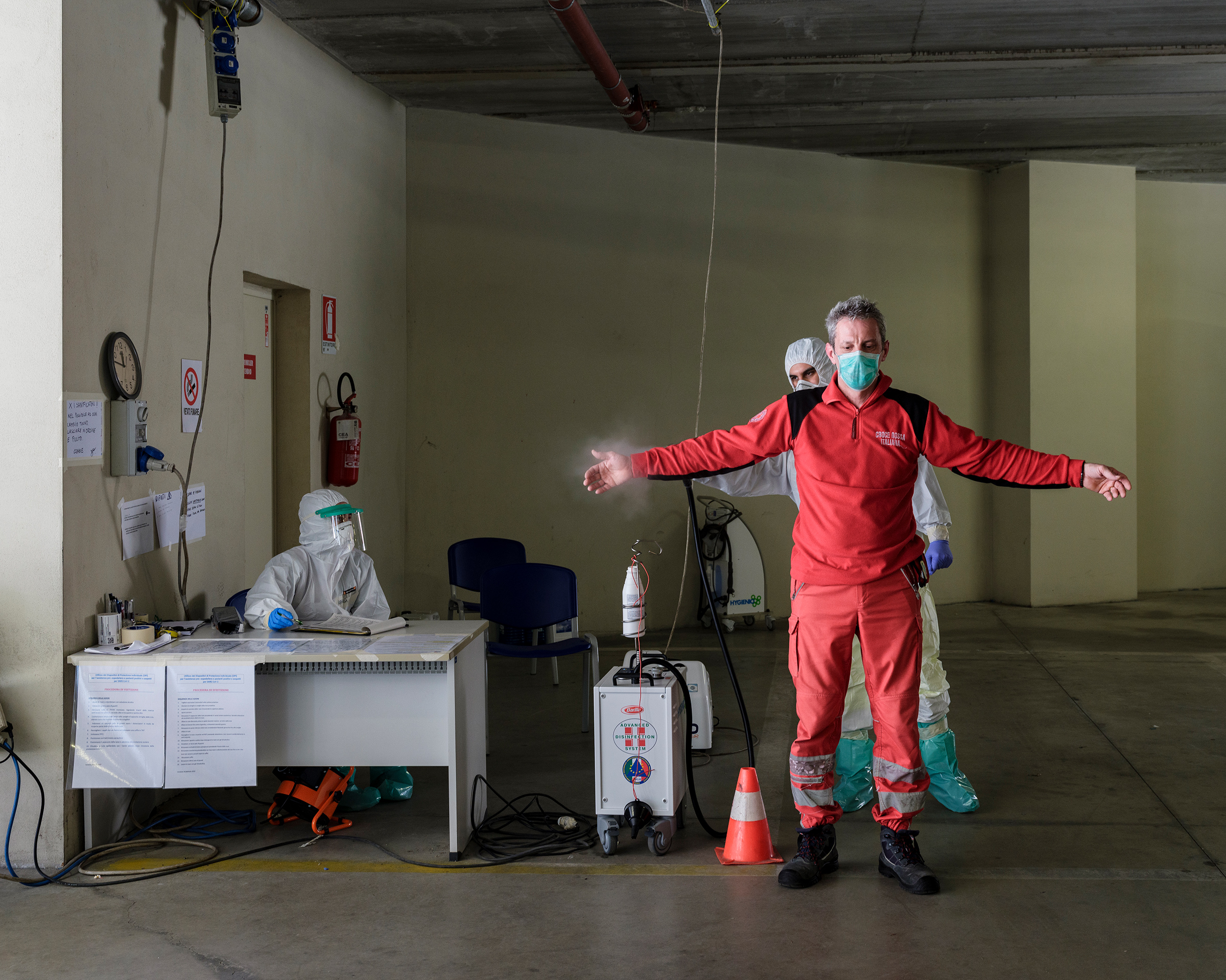 An emergency worker is disinfected after an ambulance brought a suspected COVID-19 patient to the hospital in Parma. (Lorenzo Meloni—Magnum Photos for TIME)